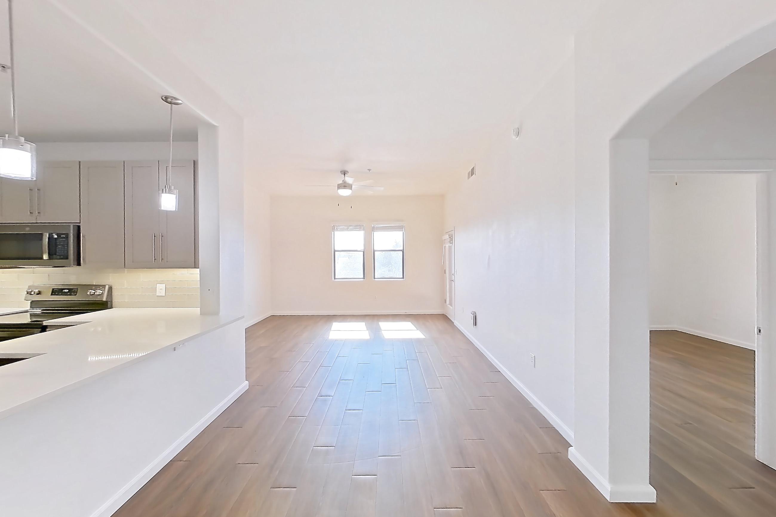 Dining room with black appliances, dark wood-finish flooring, light countertops, oven/range, refrigerator, and stainless steel appliances, Apartment 3113 at Cortland South Mountain