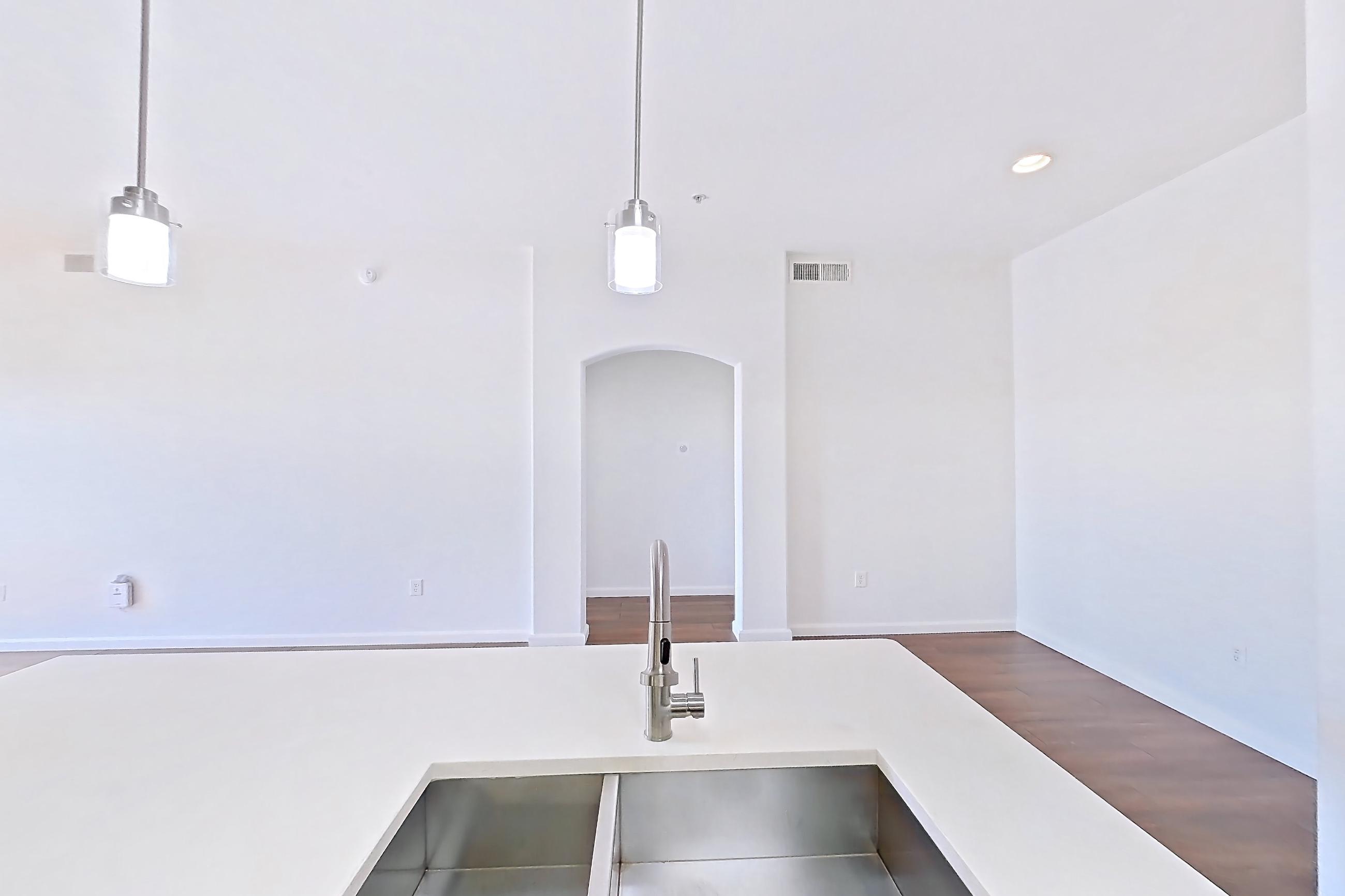 Kitchen with electric range, kitchen island, light countertops, light wood-finish flooring, microwave, oven/range, and stainless steel appliances, Apartment 3113 at Cortland South Mountain