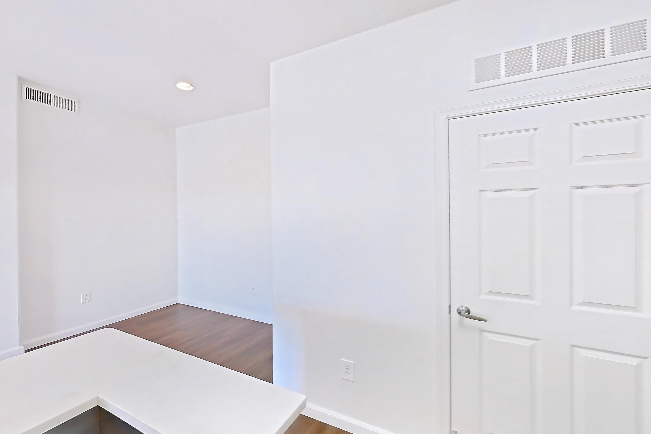 Kitchen with electric range, kitchen island, light countertops, light wood-finish flooring, microwave, oven/range, and stainless steel appliances, Apartment 3113 at Cortland South Mountain