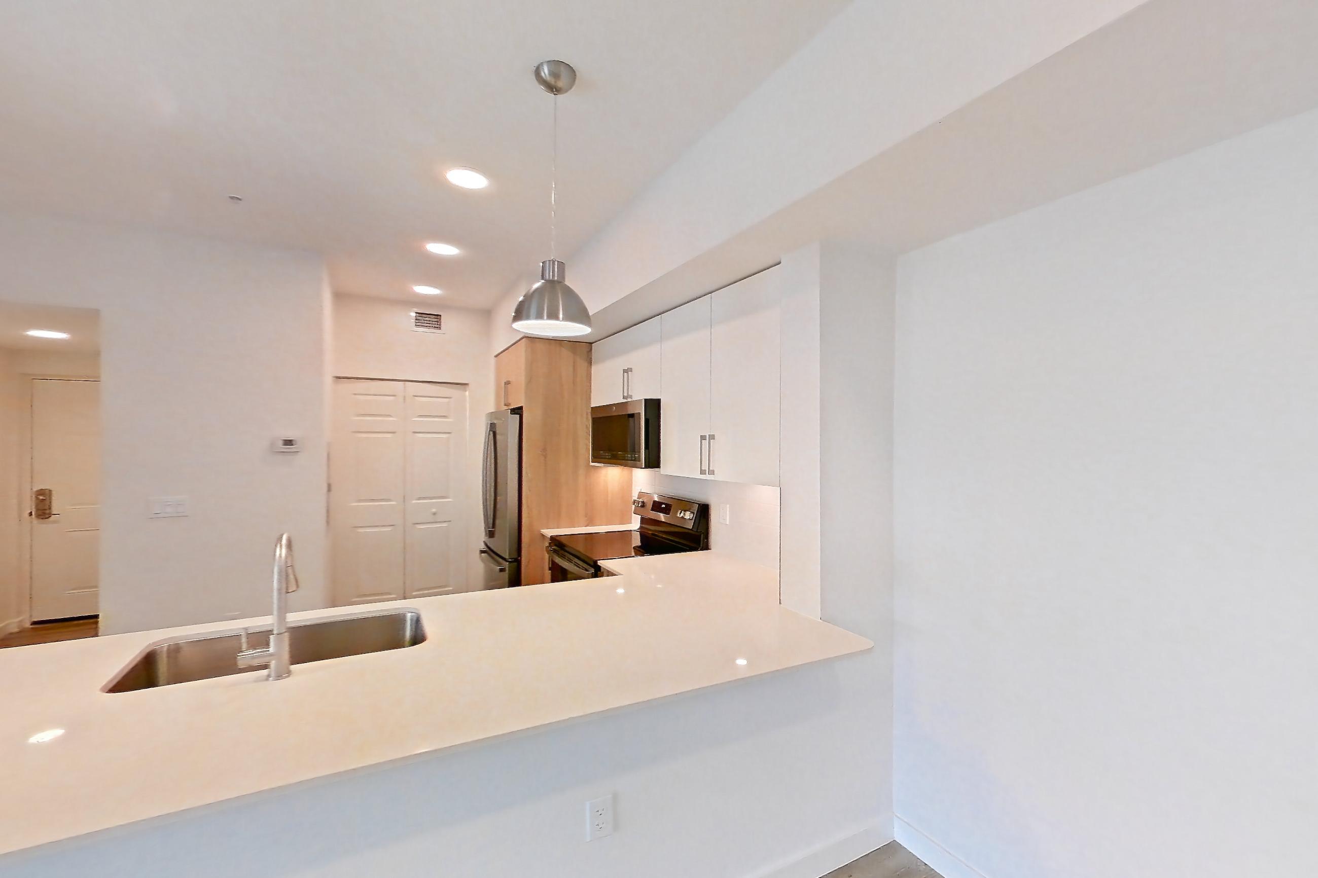 Living space with electric range, light countertops, light stone countertops, light wood-finish flooring, oven/range, refrigerator, and stainless steel appliances, Apartment 26-305 at Cortland South Kendall