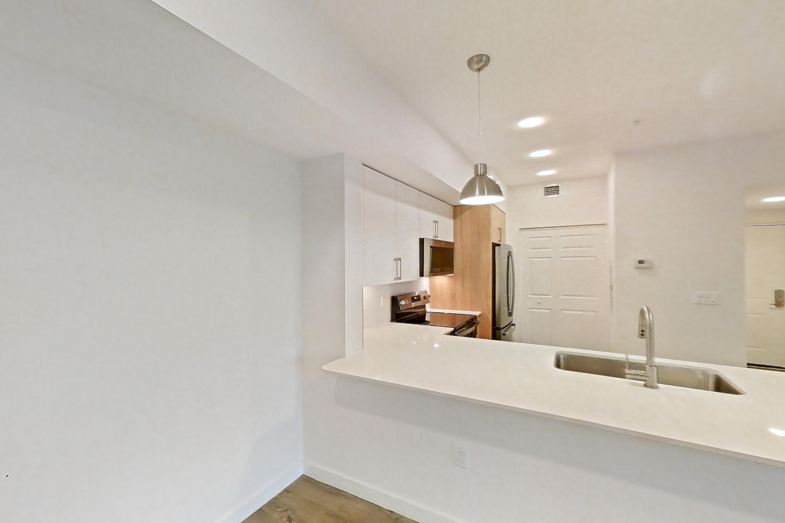Living space with electric range, light countertops, light wood-finish flooring, oven/range, refrigerator, and stainless steel appliances, Apartment 26-306 at Cortland South Kendall