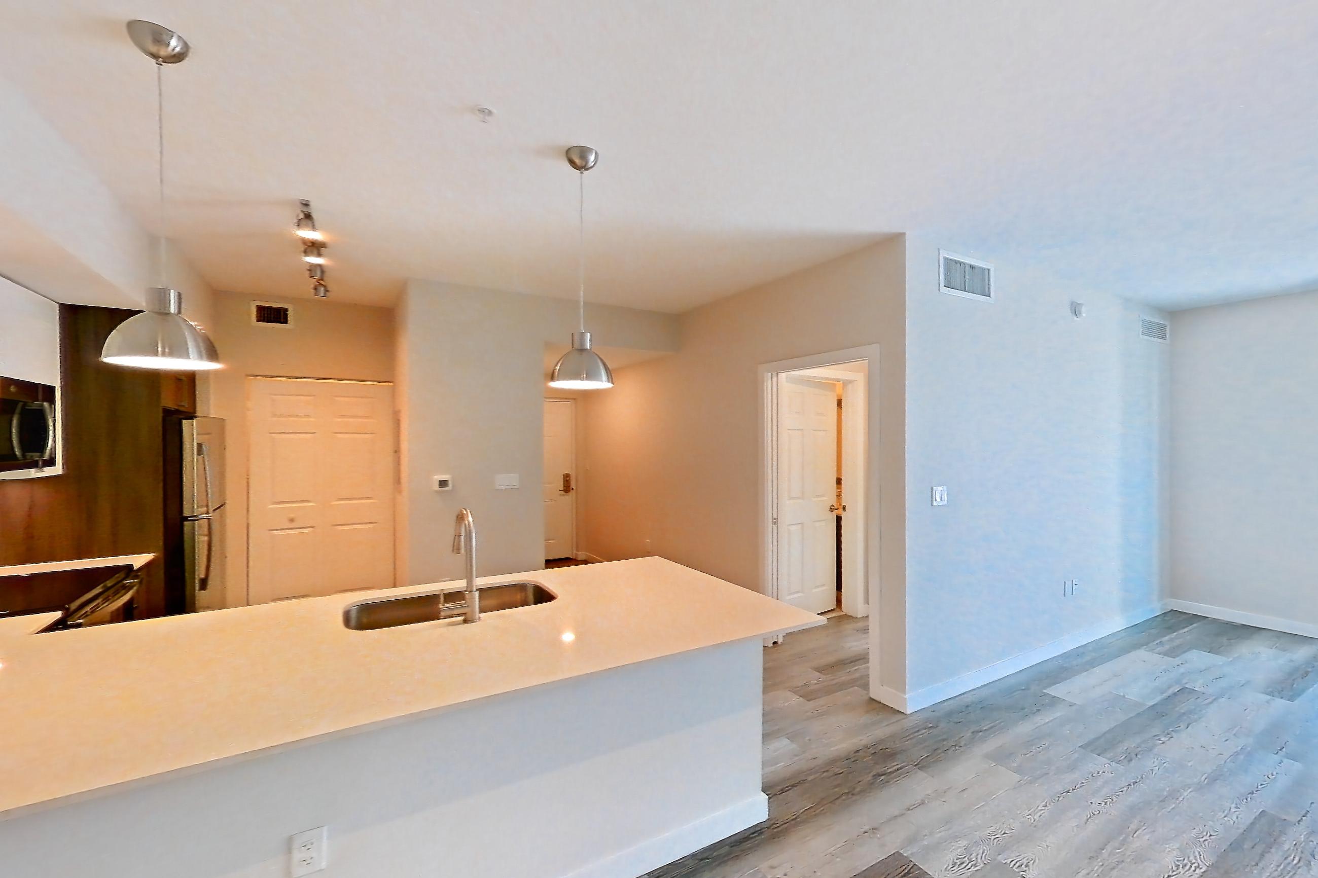 Living space with electric range, light countertops, light stone countertops, light wood-finish flooring, oven/range, and stainless steel appliances, Apartment 02-303 at Cortland South Kendall