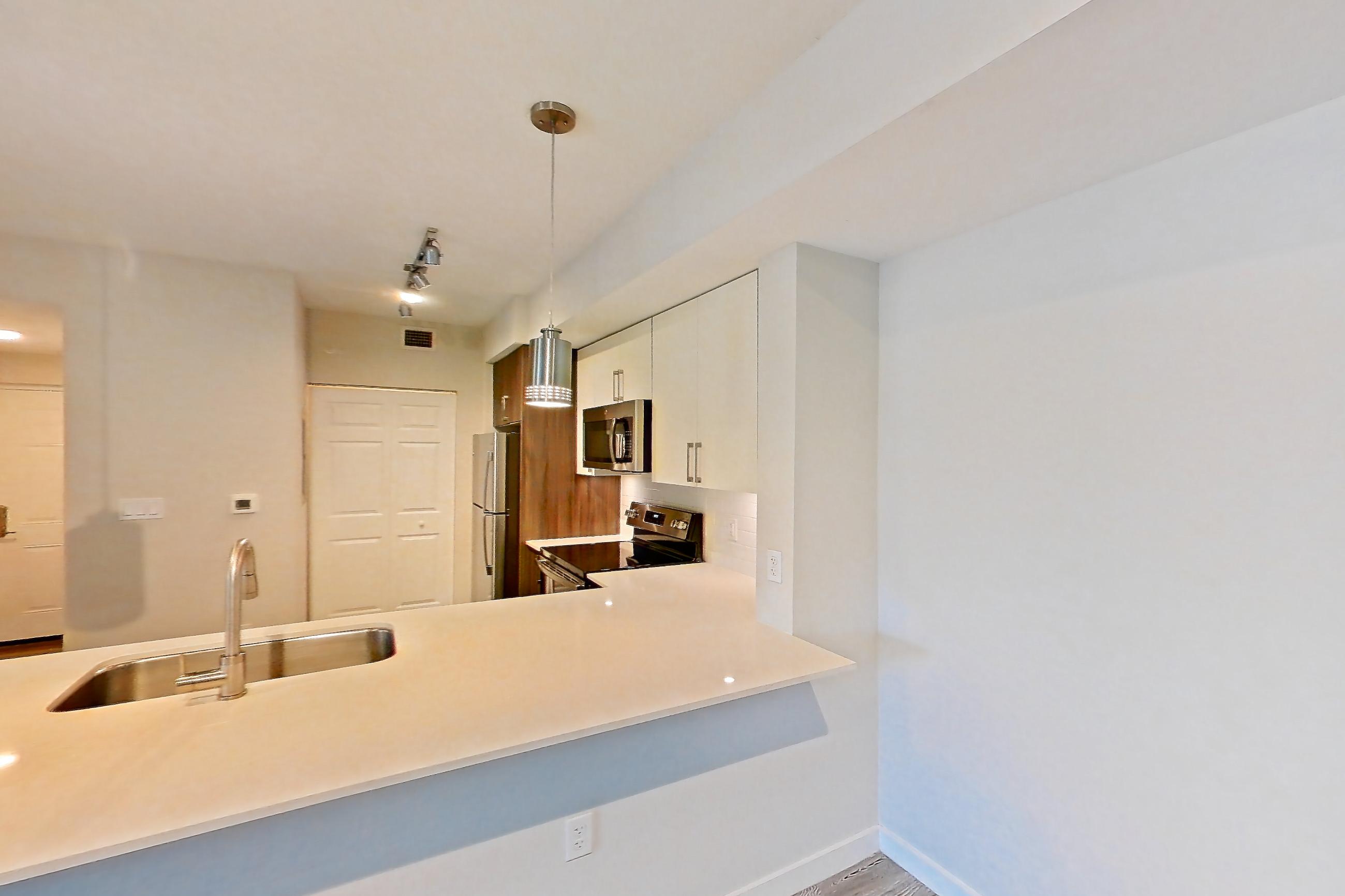 Living space with electric range, light countertops, light stone countertops, light wood-finish flooring, oven/range, refrigerator, stainless steel appliances, and white appliances, Apartment 05-204 at Cortland South Kendall