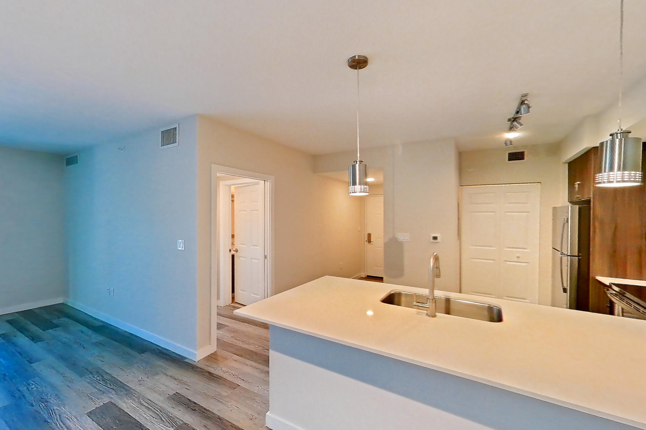 Living space with electric range, light countertops, light stone countertops, light wood-finish flooring, oven/range, refrigerator, stainless steel appliances, and white appliances, Apartment 05-204 at Cortland South Kendall
