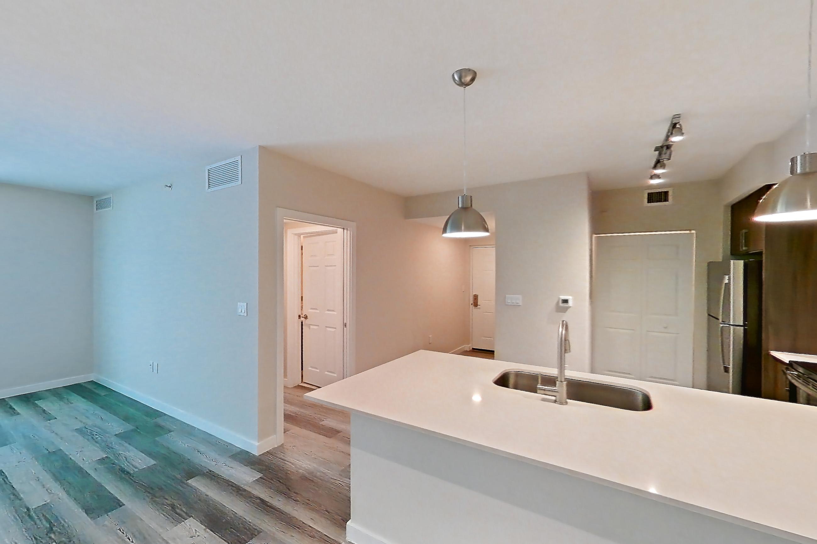 Living space with electric range, light countertops, light stone countertops, light wood-finish flooring, oven/range, refrigerator, and stainless steel appliances, Apartment 05-205 at Cortland South Kendall