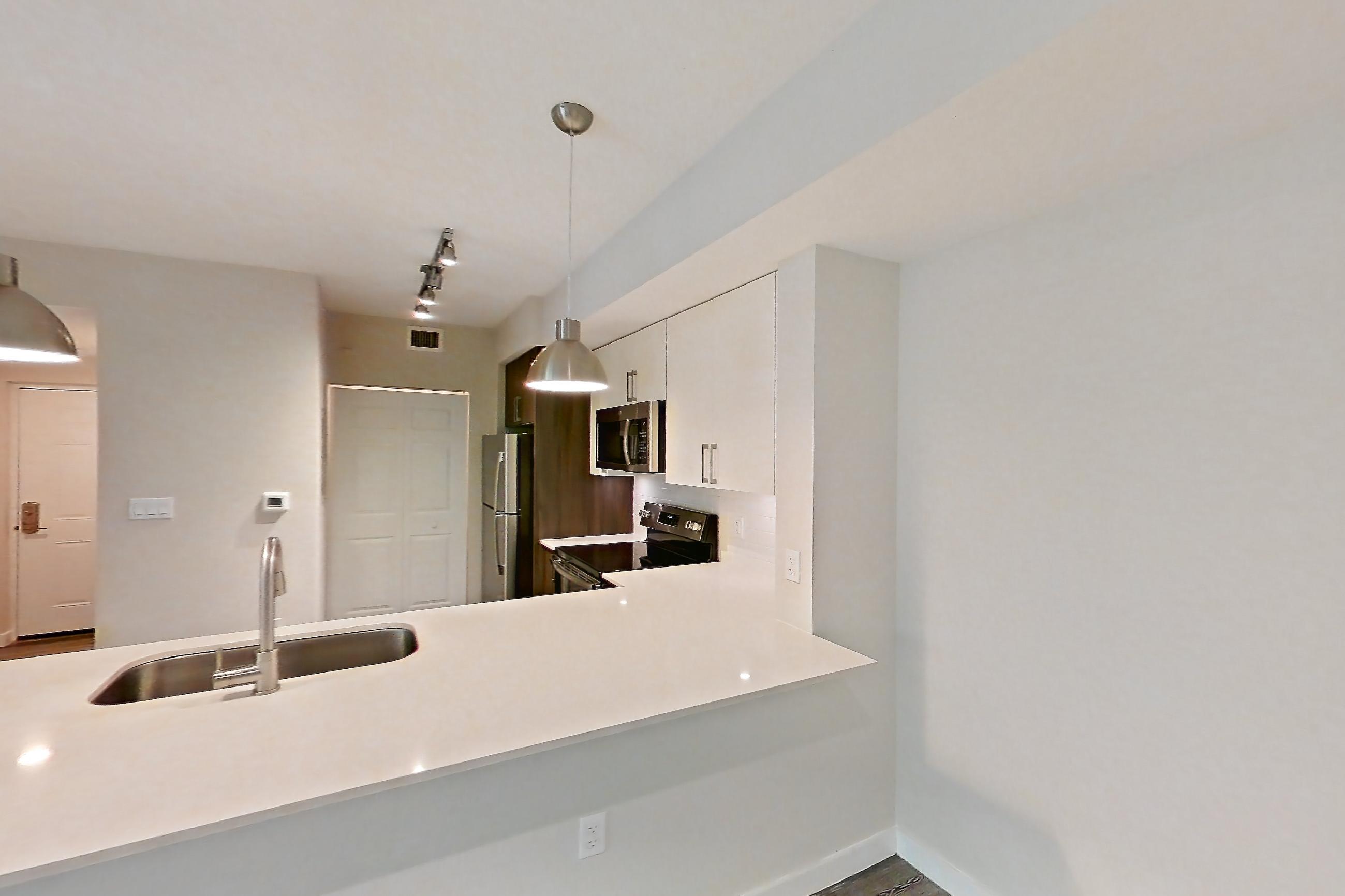 Living space with electric range, light countertops, light stone countertops, light wood-finish flooring, oven/range, refrigerator, and stainless steel appliances, Apartment 05-205 at Cortland South Kendall