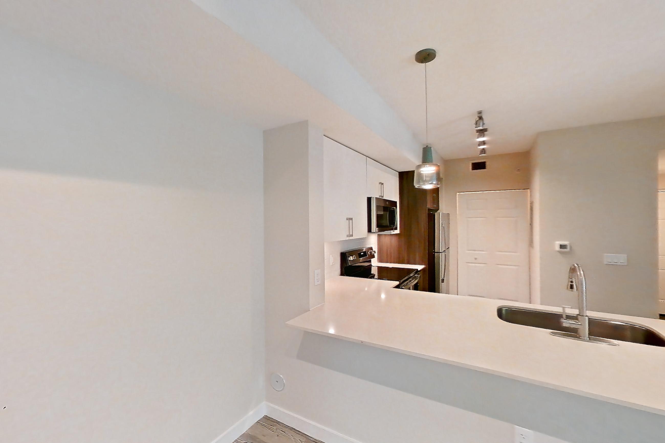 Living space with electric range, light countertops, light wood-finish flooring, oven/range, refrigerator, stainless steel appliances, and white appliances, Apartment 06-102 at Cortland South Kendall