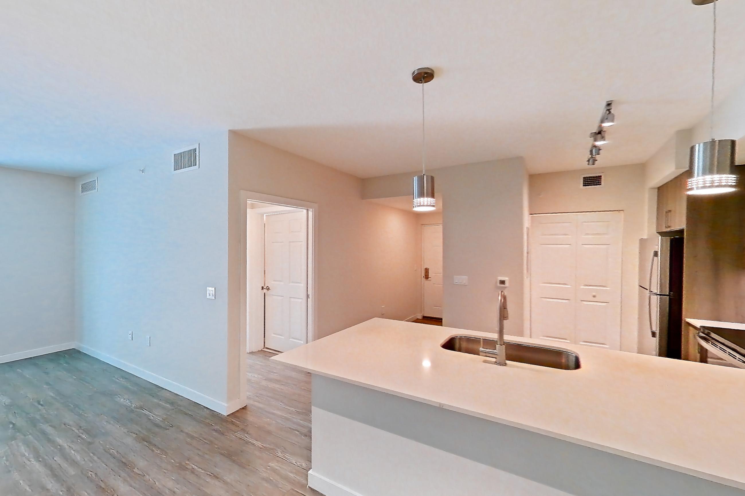 Living space with electric range, light stone countertops, light wood-finish flooring, oven/range, refrigerator, stainless steel appliances, and white appliances, Apartment 10-101 at Cortland South Kendall