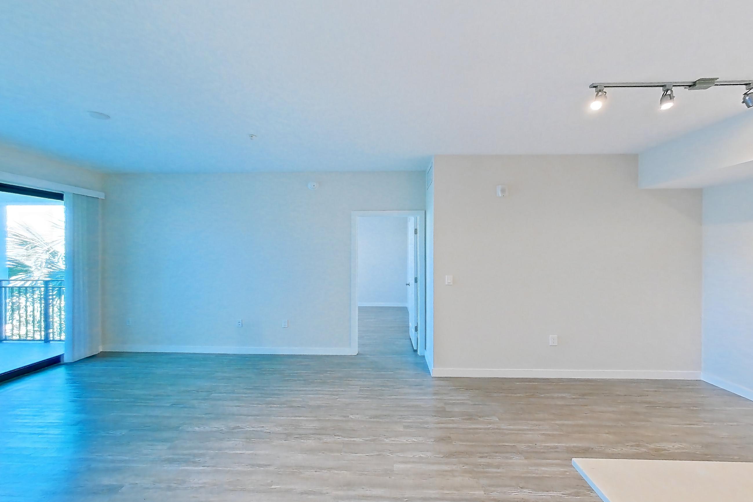 Kitchen entryway with electric range, light stone countertops, light wood-finish flooring, oven/range, refrigerator, and stainless steel appliances, Apartment 11-307 at Cortland South Kendall