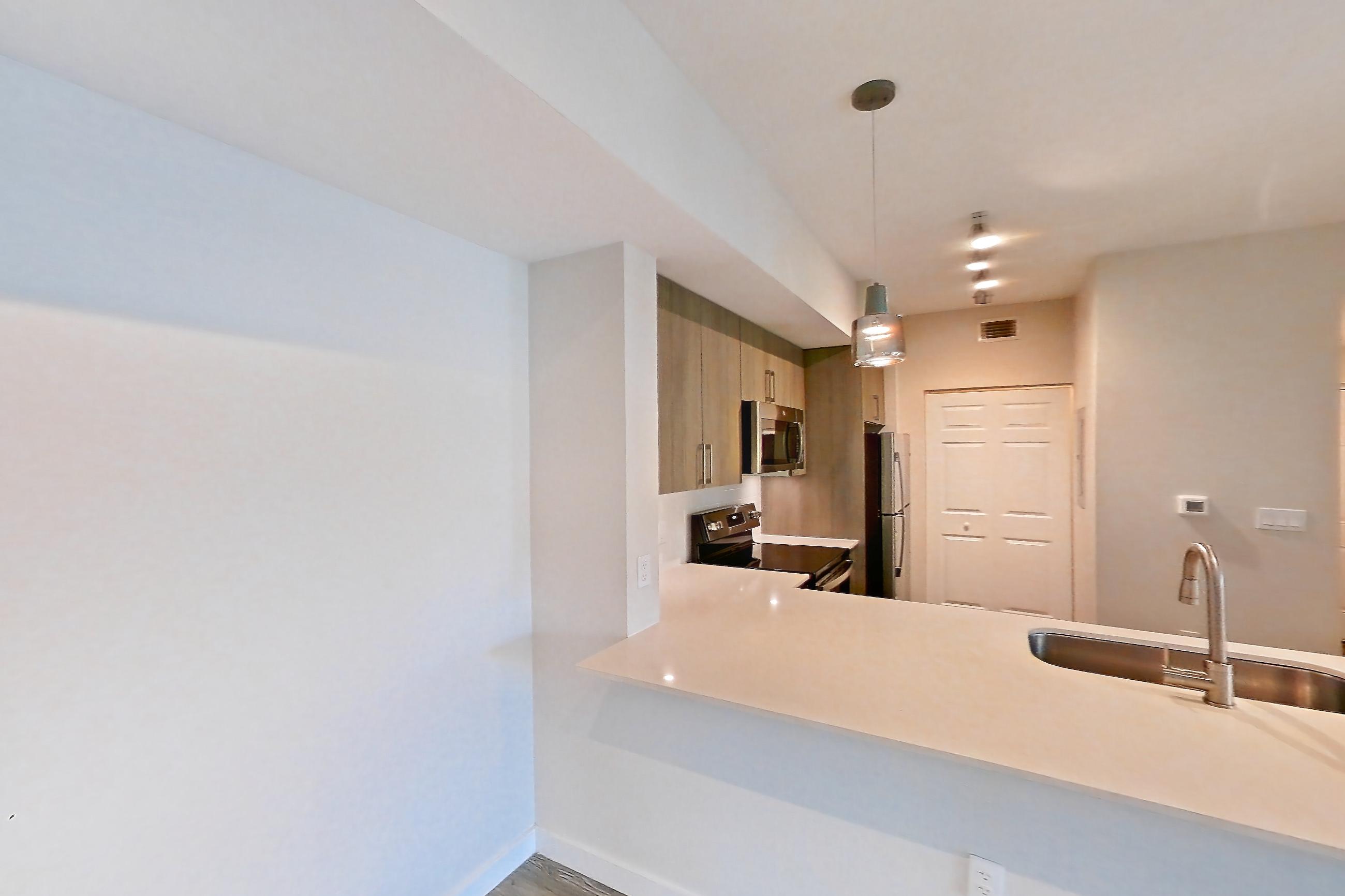 Living space with electric range, light countertops, light wood-finish flooring, oven/range, refrigerator, stainless steel appliances, and white appliances, Apartment 11-307 at Cortland South Kendall