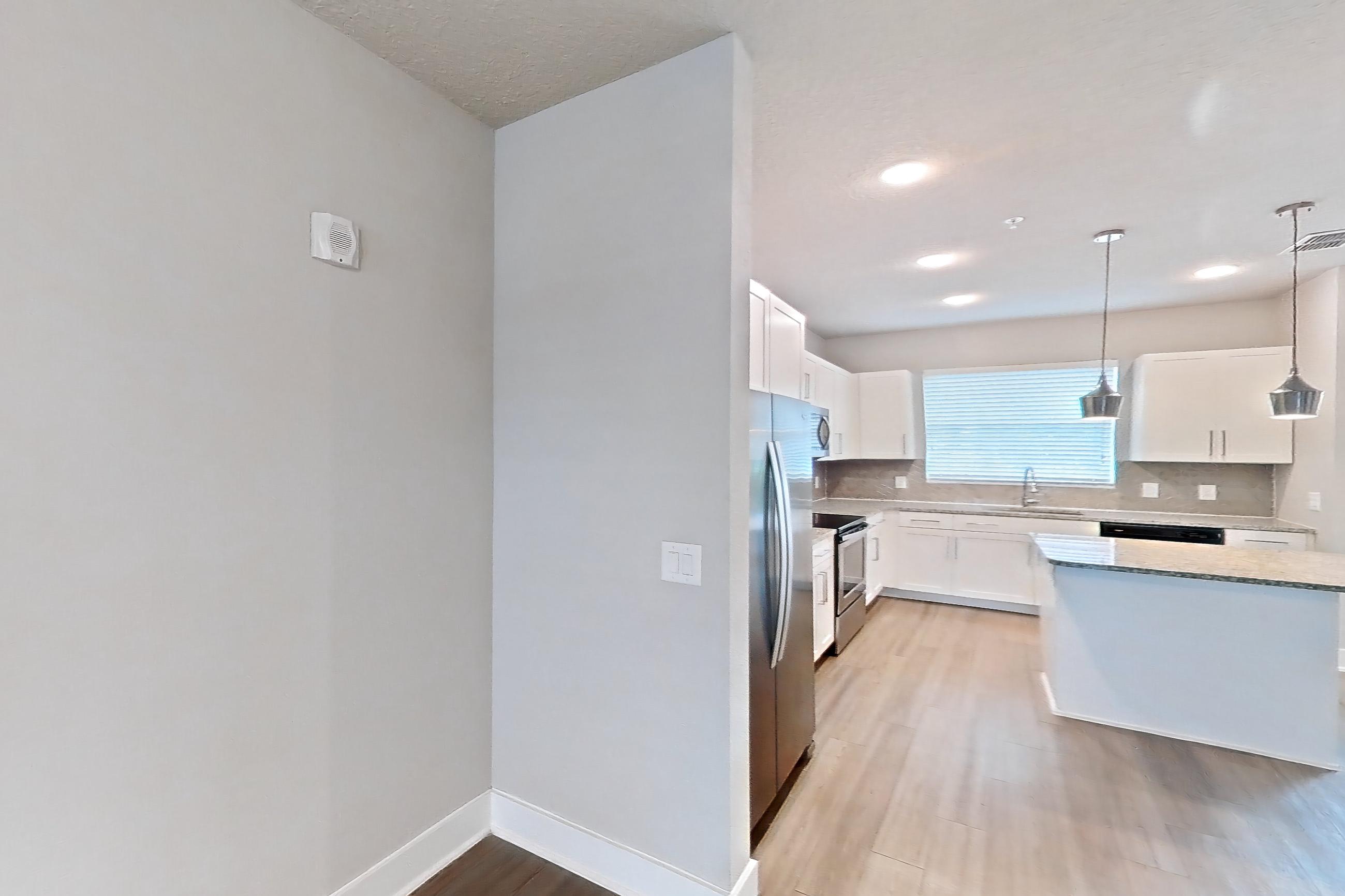 Living room with dark wood-finish flooring, electric range, light wood-finish flooring, oven/range, refrigerator, and stainless steel appliances, Apartment 04-186 at Cortland Reunion