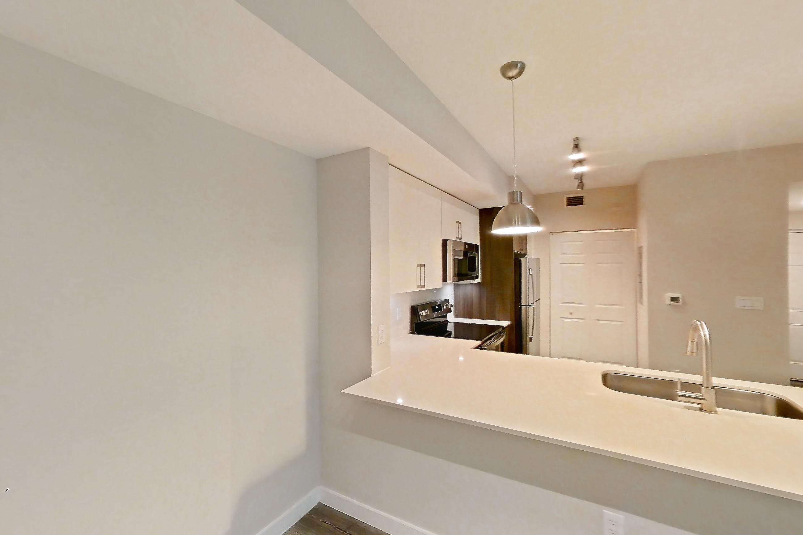 Living space with electric range, light countertops, light wood-finish flooring, oven/range, refrigerator, stainless steel appliances, and white appliances, Apartment 13-203 at Cortland South Kendall