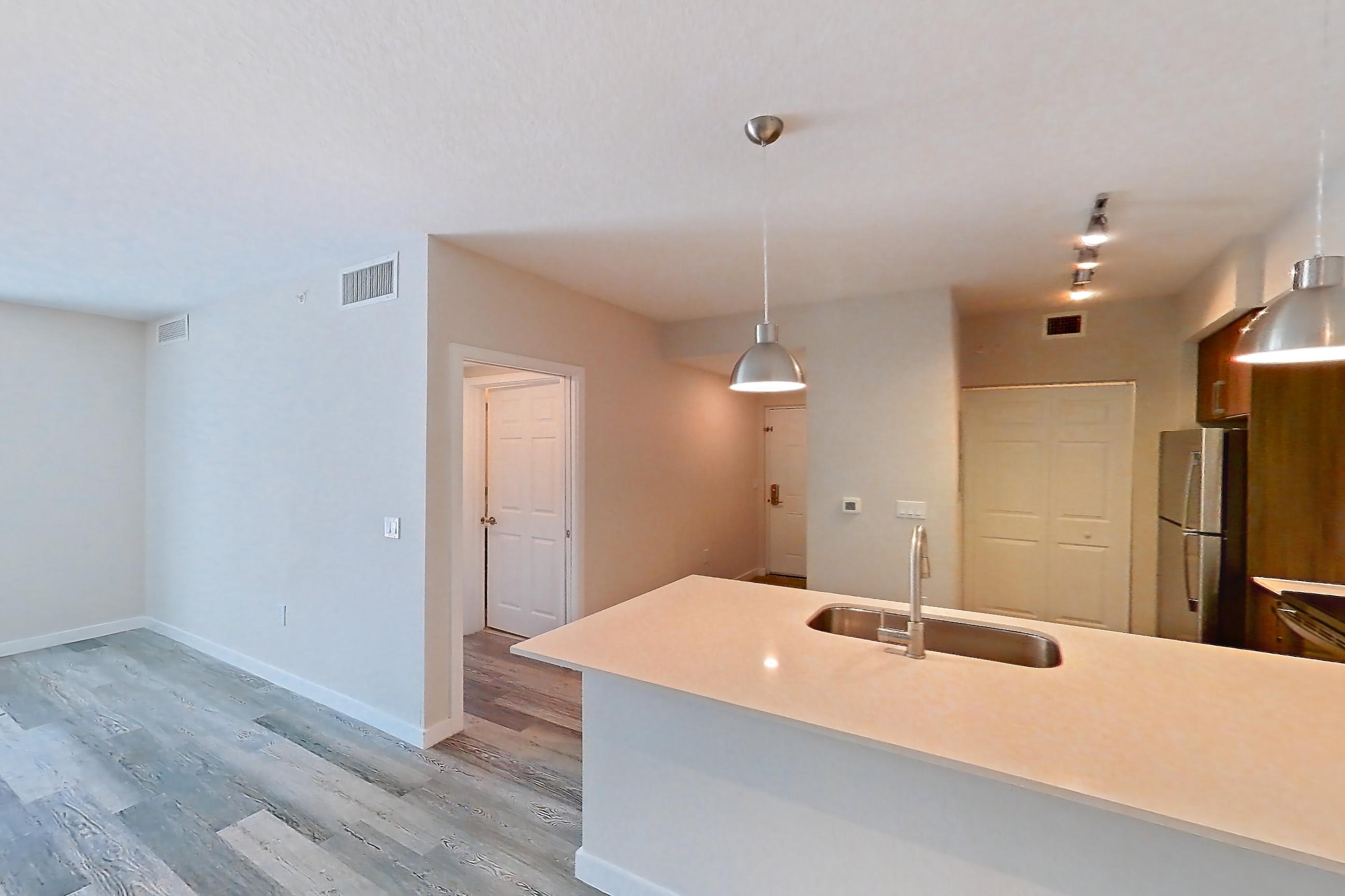 Living space with electric range, light countertops, light stone countertops, light wood-finish flooring, oven/range, refrigerator, and stainless steel appliances, Apartment 15-108 at Cortland South Kendall