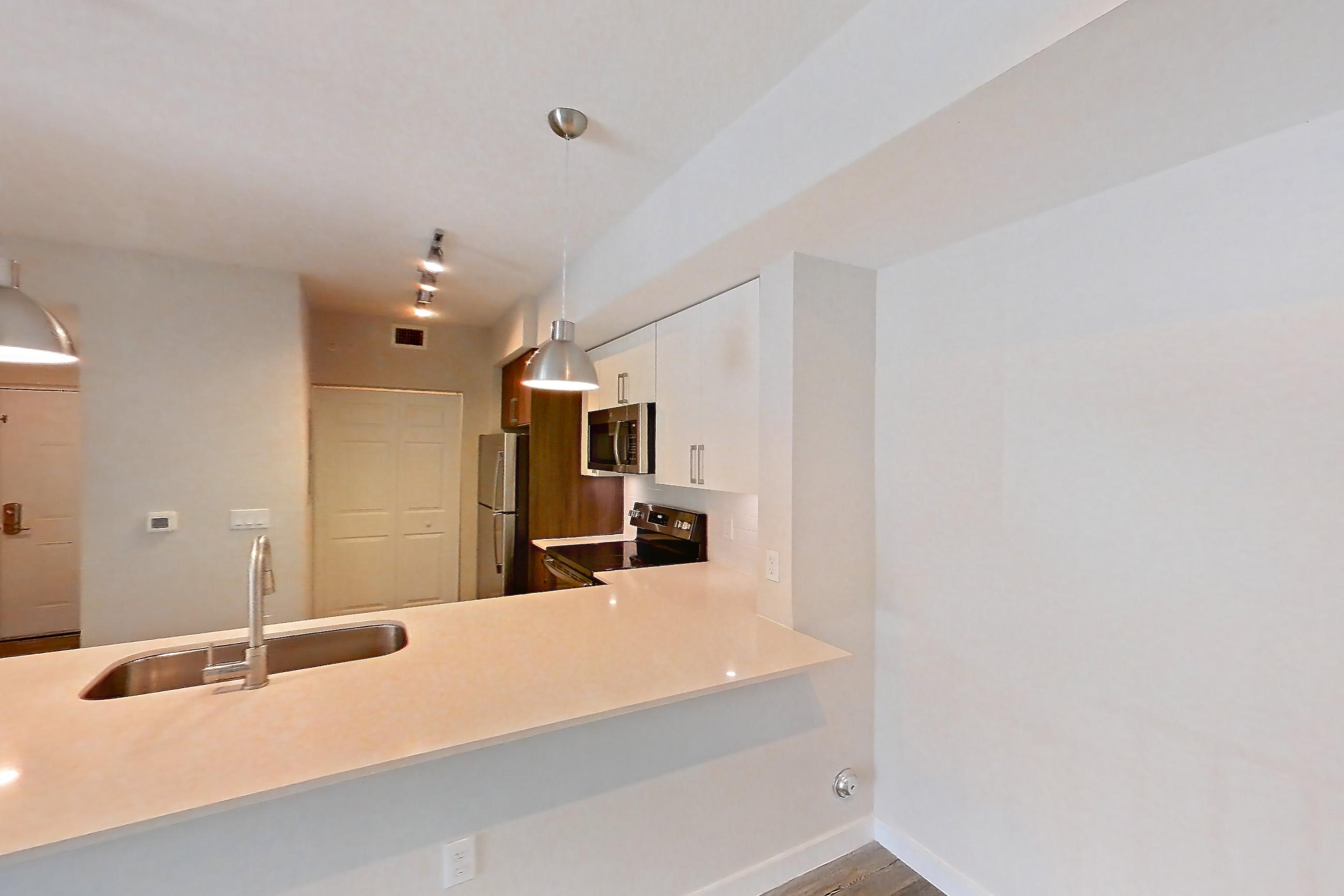 Living space with electric range, light countertops, light stone countertops, light wood-finish flooring, oven/range, refrigerator, and stainless steel appliances, Apartment 15-108 at Cortland South Kendall