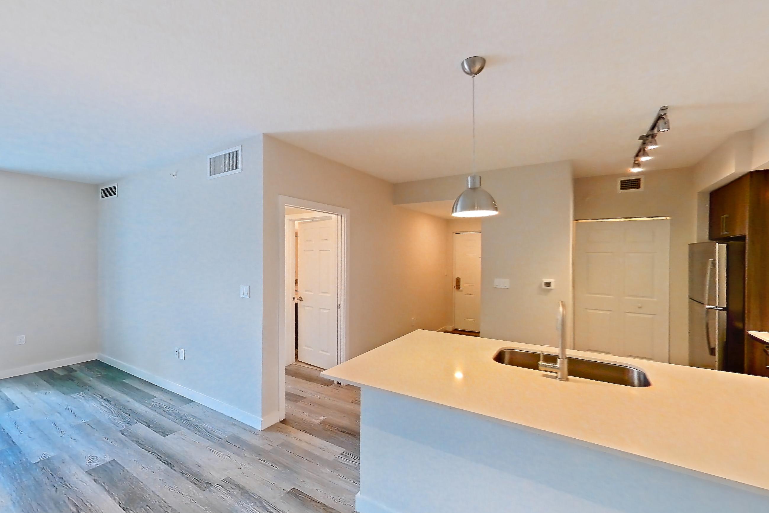 Living space with electric range, light stone countertops, light wood-finish flooring, oven/range, refrigerator, and stainless steel appliances, Apartment 17-205 at Cortland South Kendall