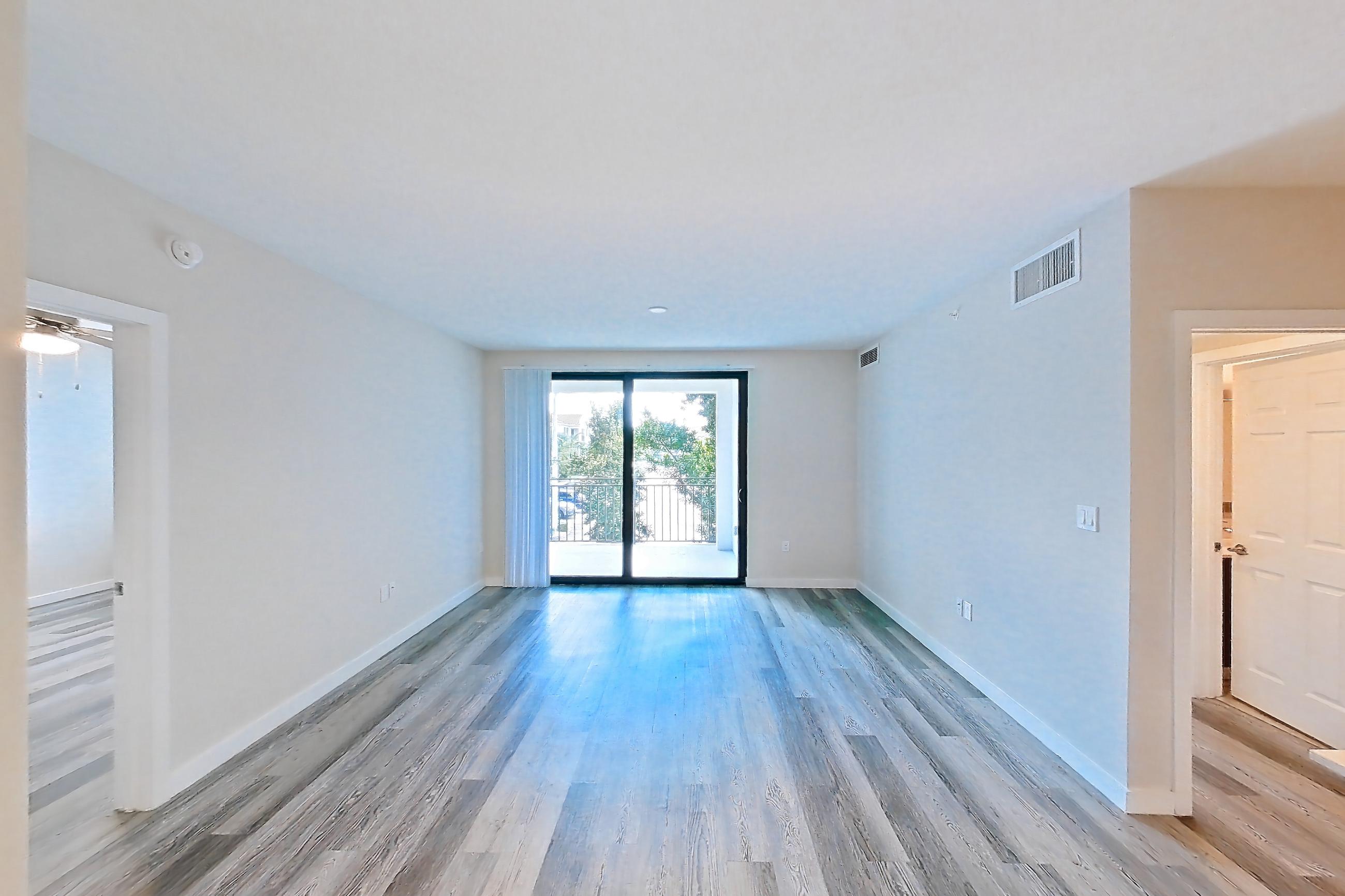 Living space with electric range, light stone countertops, light wood-finish flooring, oven/range, refrigerator, and stainless steel appliances, Apartment 17-205 at Cortland South Kendall