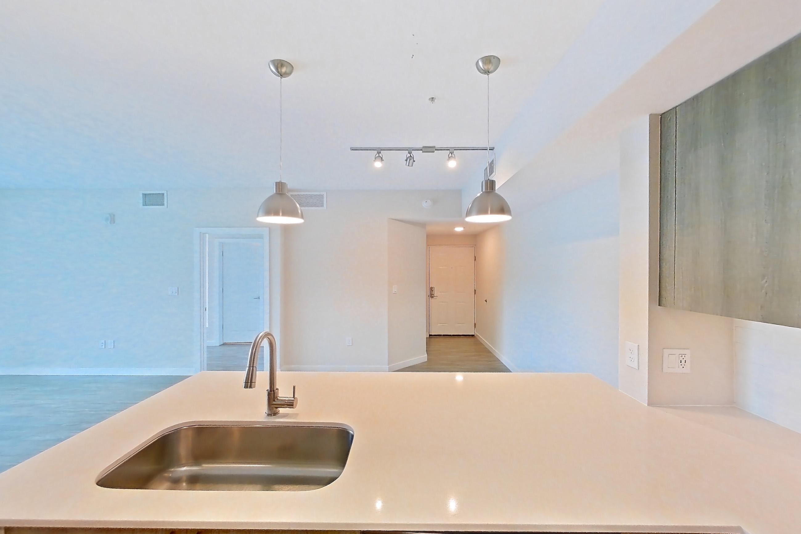 Kitchen with dishwasher, electric range, light countertops, light stone countertops, light wood-finish flooring, microwave, oven/range, and stainless steel appliances, Apartment 08-301 at Cortland South Kendall