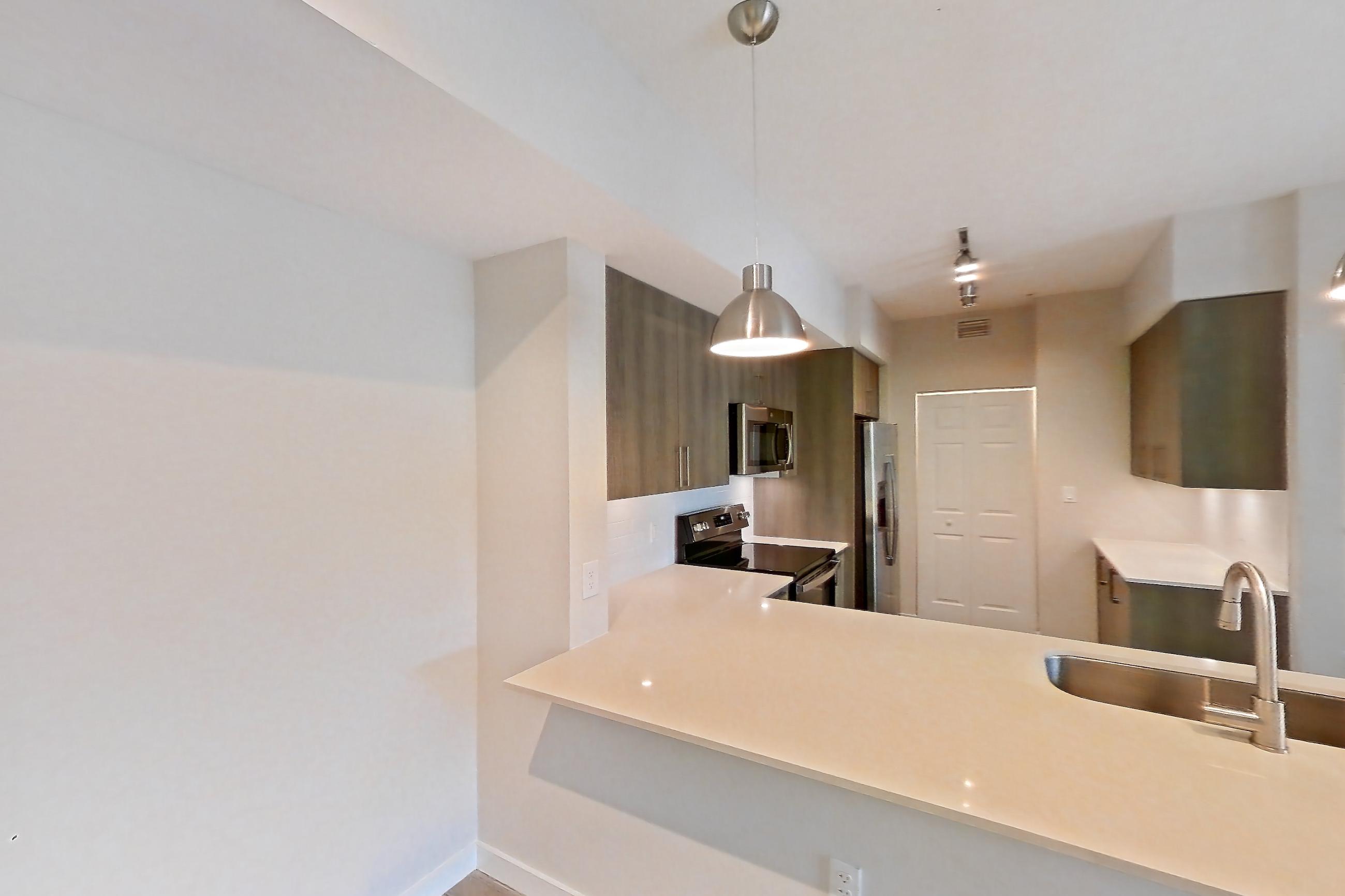 Living space with electric range, light stone countertops, light wood-finish flooring, oven/range, refrigerator, and stainless steel appliances, Apartment 08-301 at Cortland South Kendall