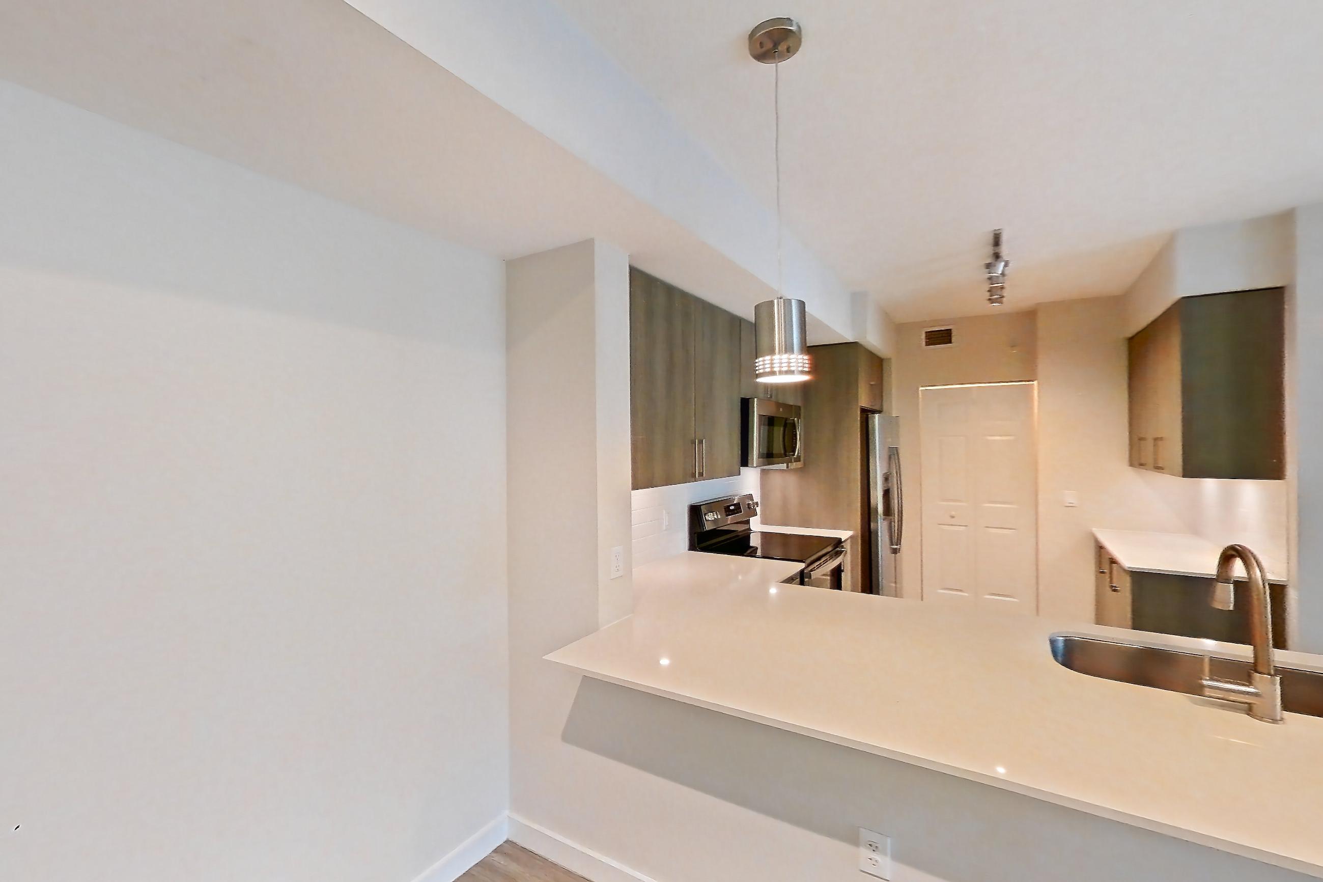 Living space with electric range, light stone countertops, light wood-finish flooring, oven/range, refrigerator, and stainless steel appliances, Apartment 08-201 at Cortland South Kendall