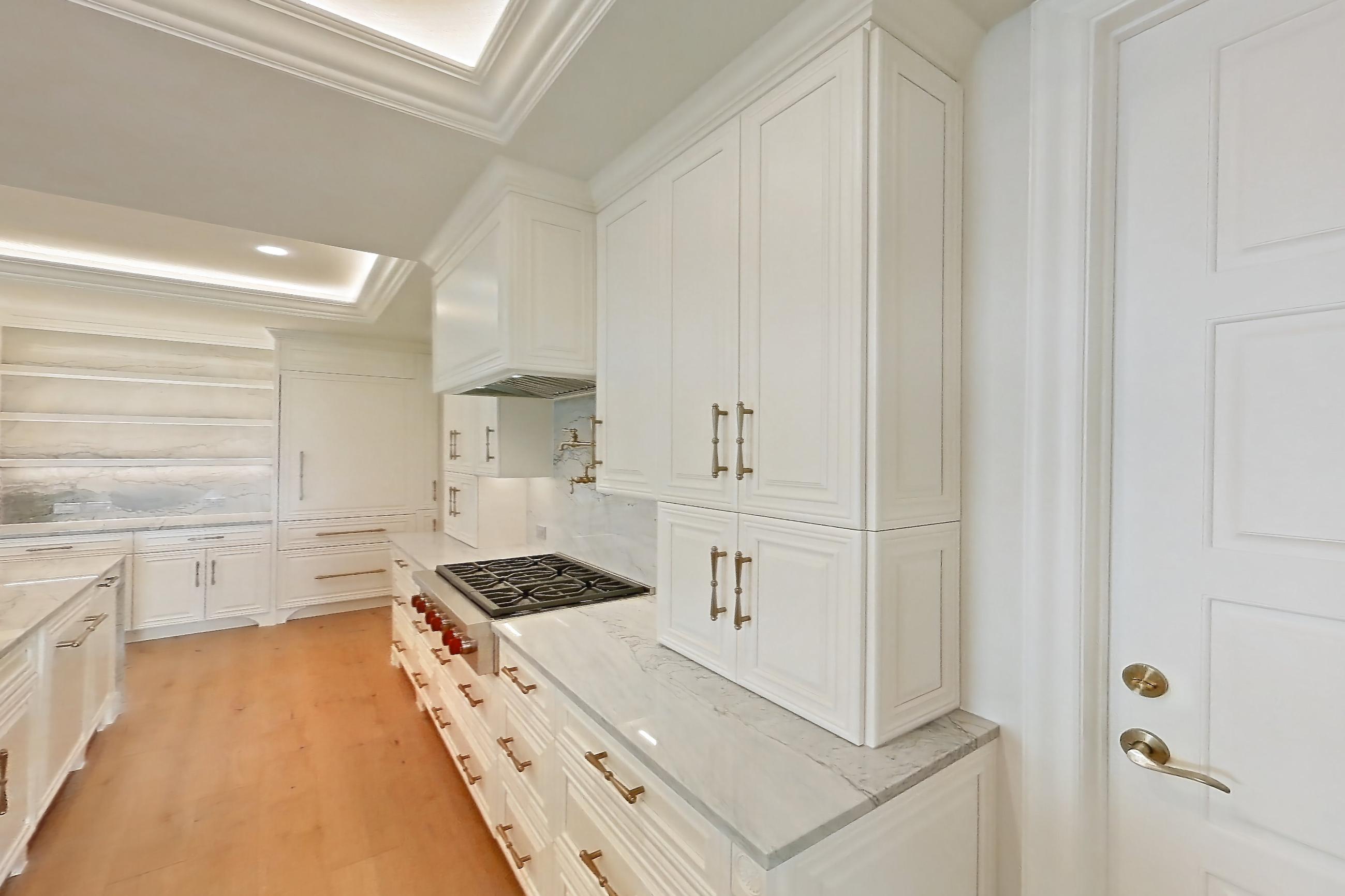 Kitchen space 2 with cooktop, gas cooktop, kitchen island, light stone countertops, light wood-finish flooring, oven/range, stainless steel appliances, and wood-finish flooring, Apartment 1807 at The Langley