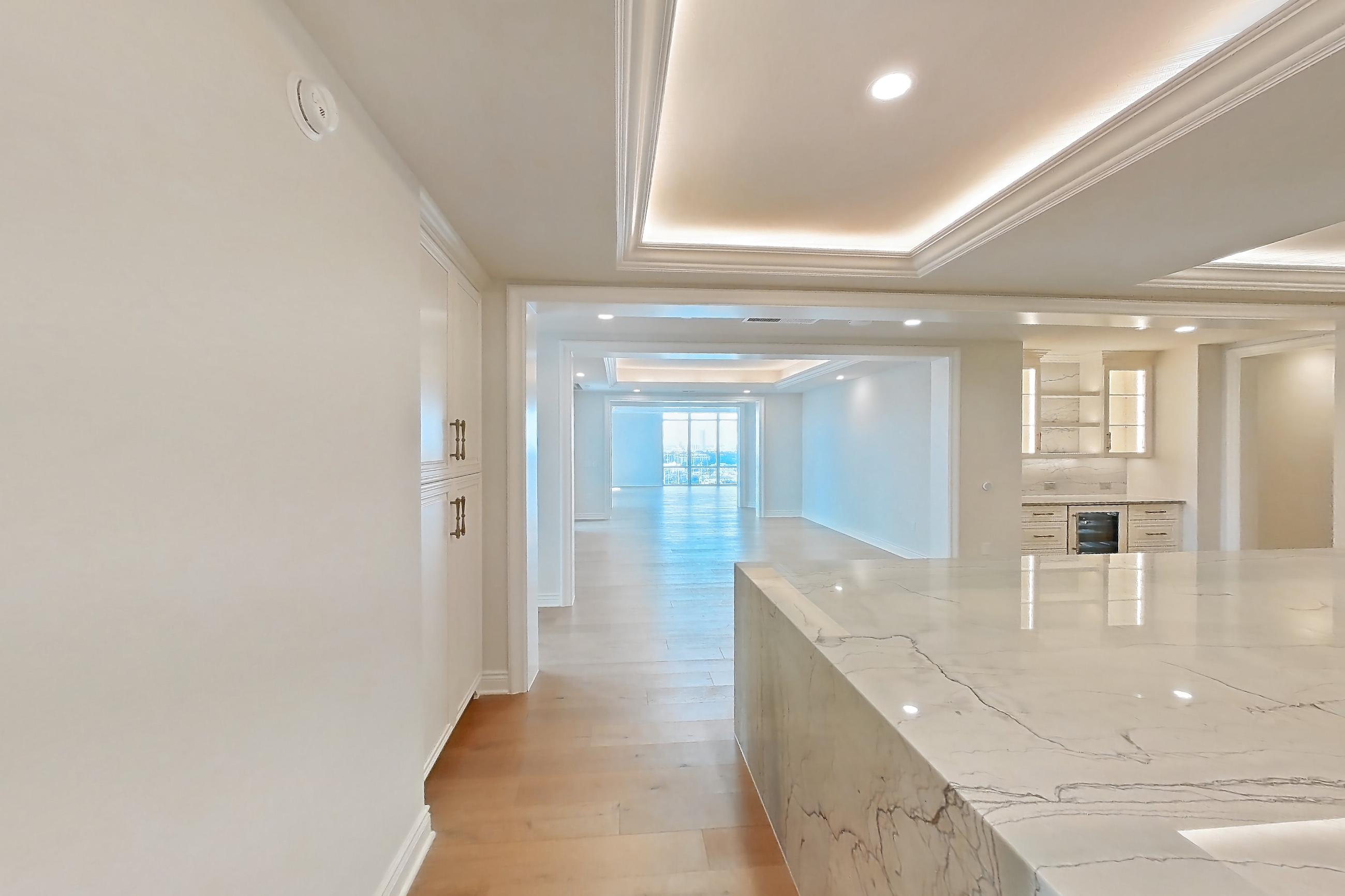 Kitchen space 2 with cooktop, gas cooktop, kitchen island, light stone countertops, light wood-finish flooring, oven/range, stainless steel appliances, and wood-finish flooring, Apartment 1807 at The Langley