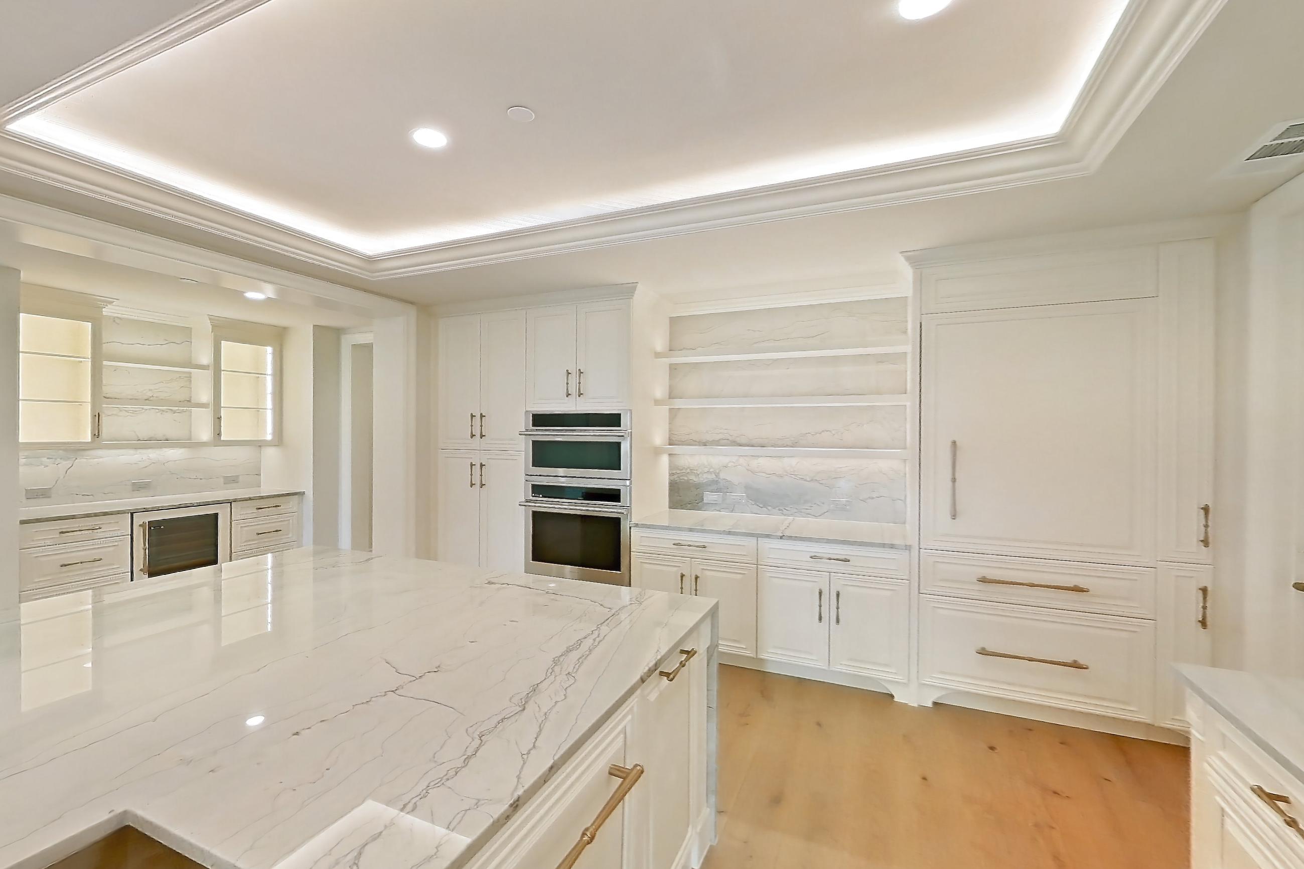 Kitchen with cooktop, double oven, gas cooktop, light stone countertops, light wood-finish flooring, stainless steel appliances, and wood-finish flooring, Apartment 1807 at The Langley