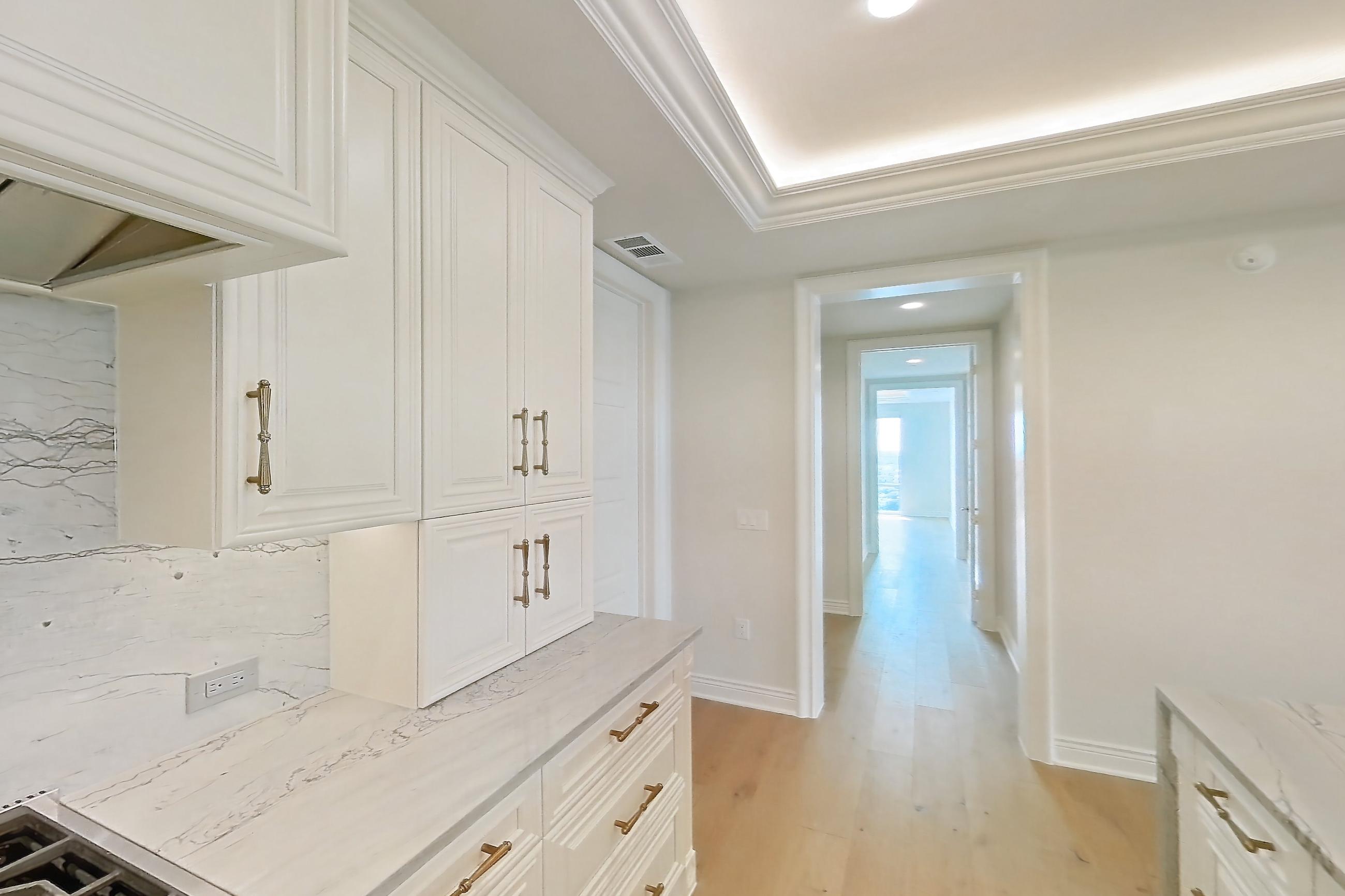 Kitchen with cooktop, double oven, gas cooktop, light stone countertops, light wood-finish flooring, stainless steel appliances, and wood-finish flooring, Apartment 1807 at The Langley