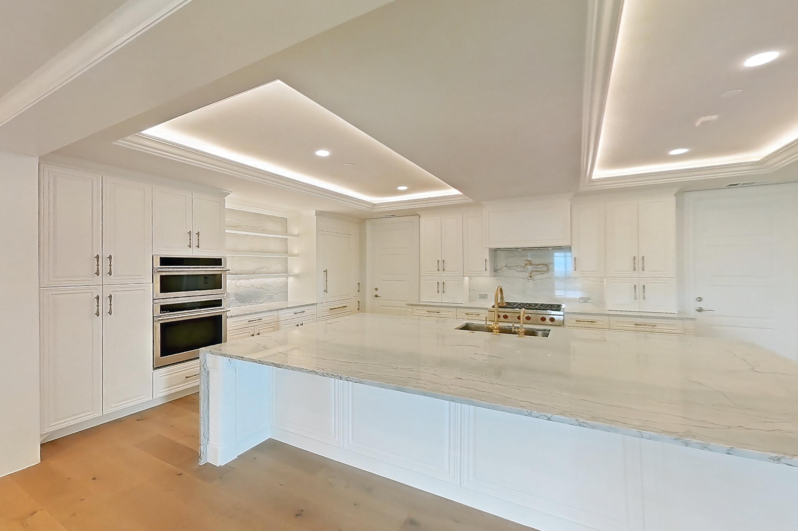 Living space with gas range, kitchen island, light stone countertops, light wood-finish flooring, oven/range, stainless steel appliances, and wood-finish flooring, Apartment 1807 at The Langley