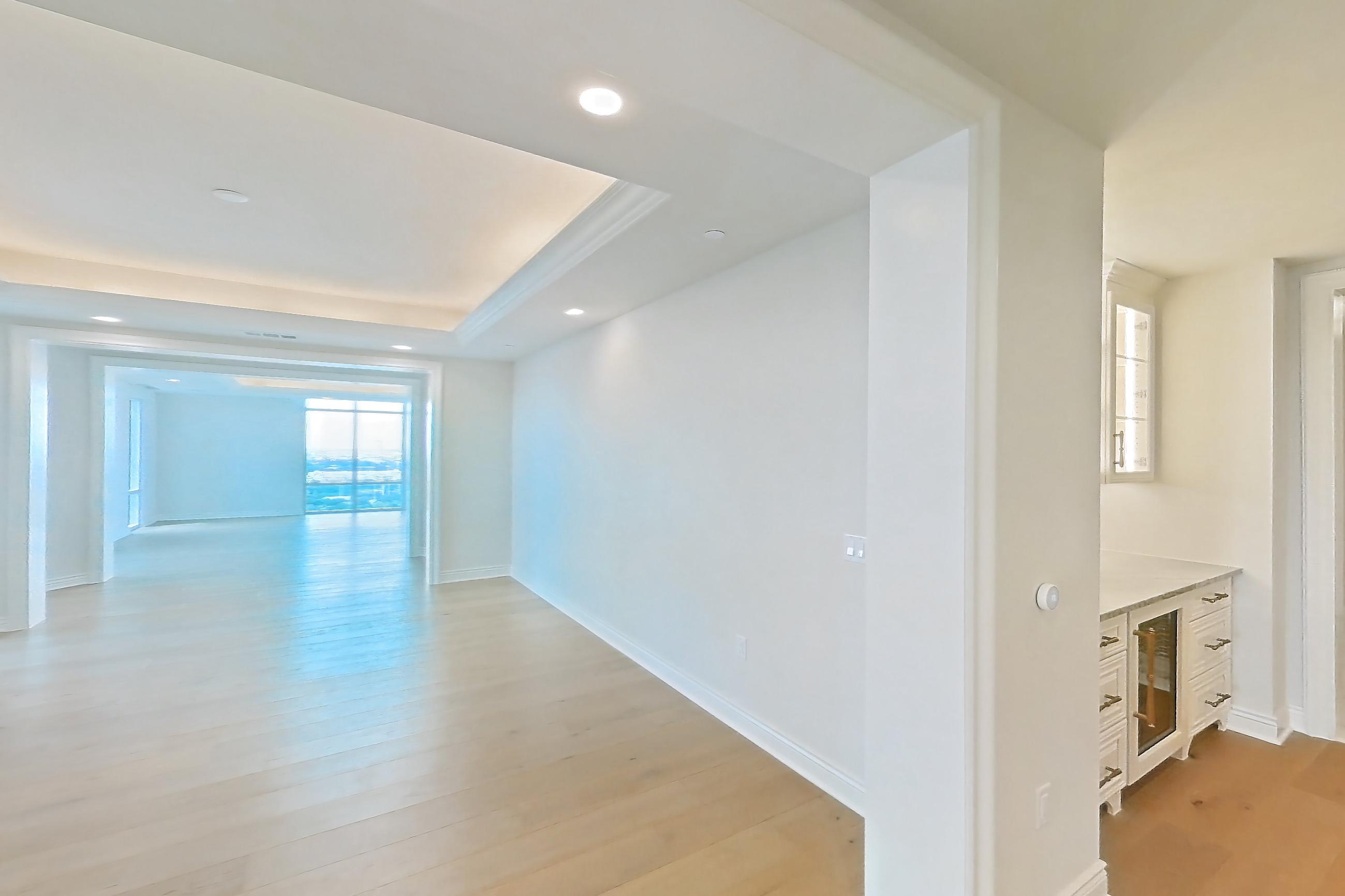 Living space with gas range, kitchen island, light stone countertops, light wood-finish flooring, oven/range, stainless steel appliances, and wood-finish flooring, Apartment 1807 at The Langley