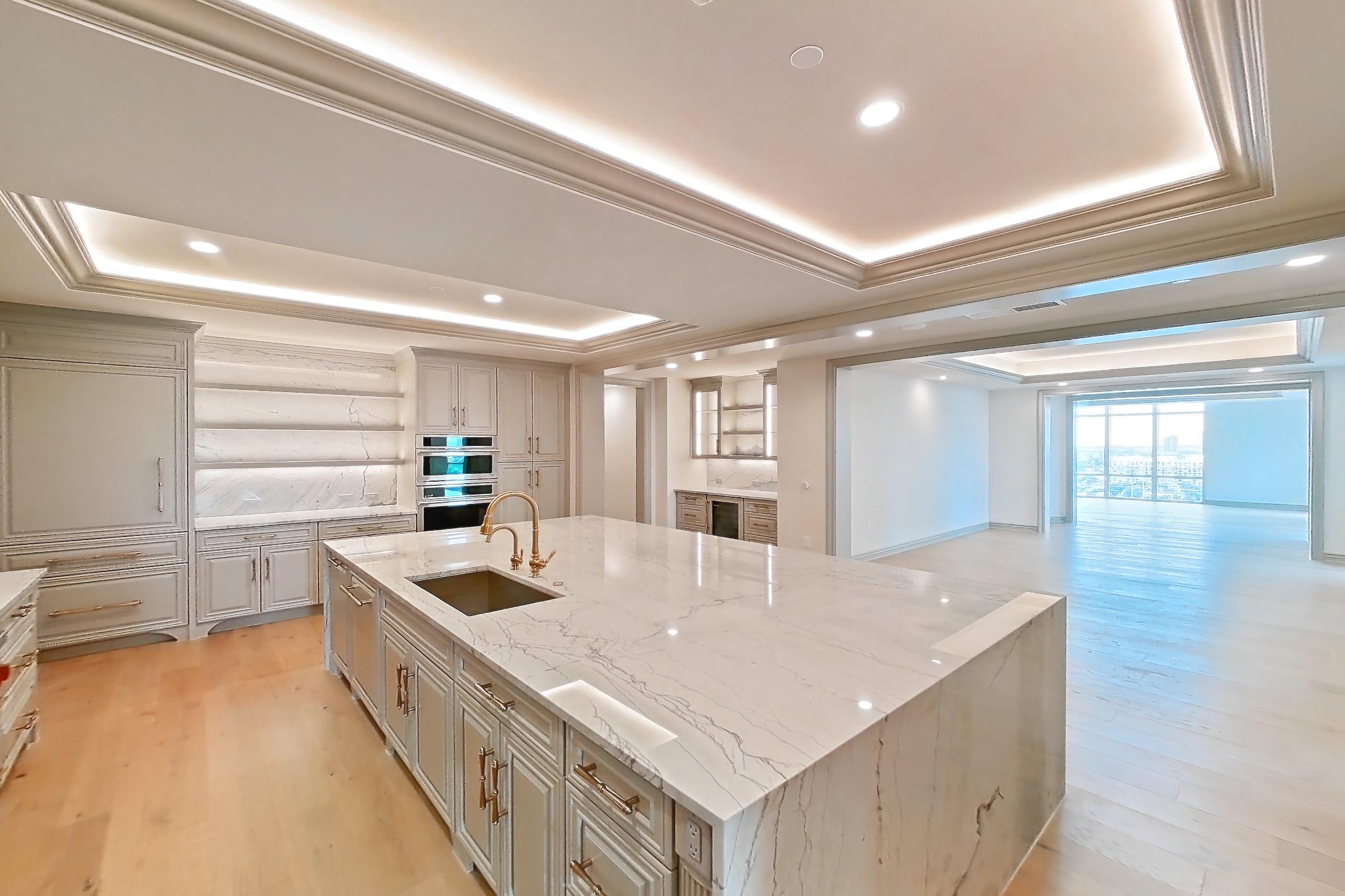 Kitchen space 2 with kitchen island, light stone countertops, light wood-finish flooring, oven/range, and stainless steel appliances, Apartment 1902 at The Langley