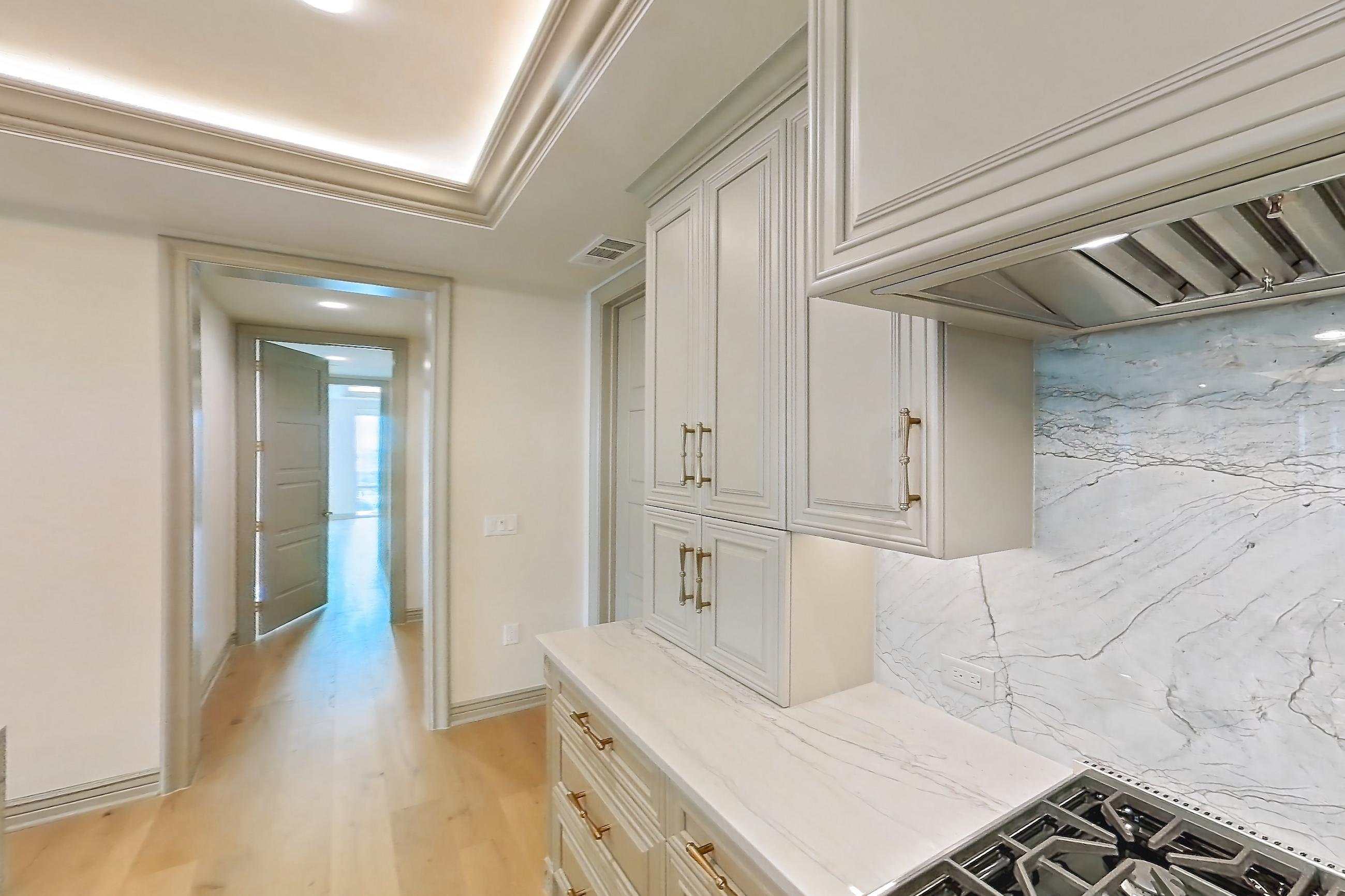 Kitchen with gas range, kitchen island, light stone countertops, light wood-finish flooring, oven/range, and stainless steel appliances, Apartment 1902 at The Langley