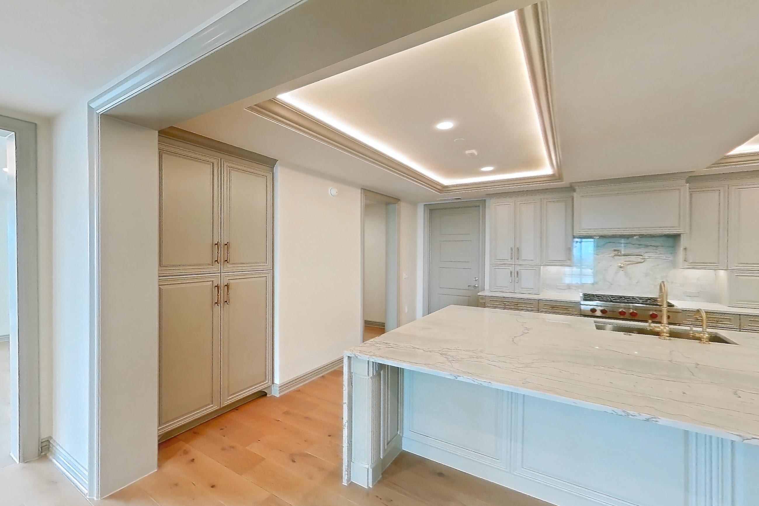 Living space with gas range, kitchen island, light stone countertops, light wood-finish flooring, oven/range, stainless steel appliances, and wood-finish flooring, Apartment 1902 at The Langley