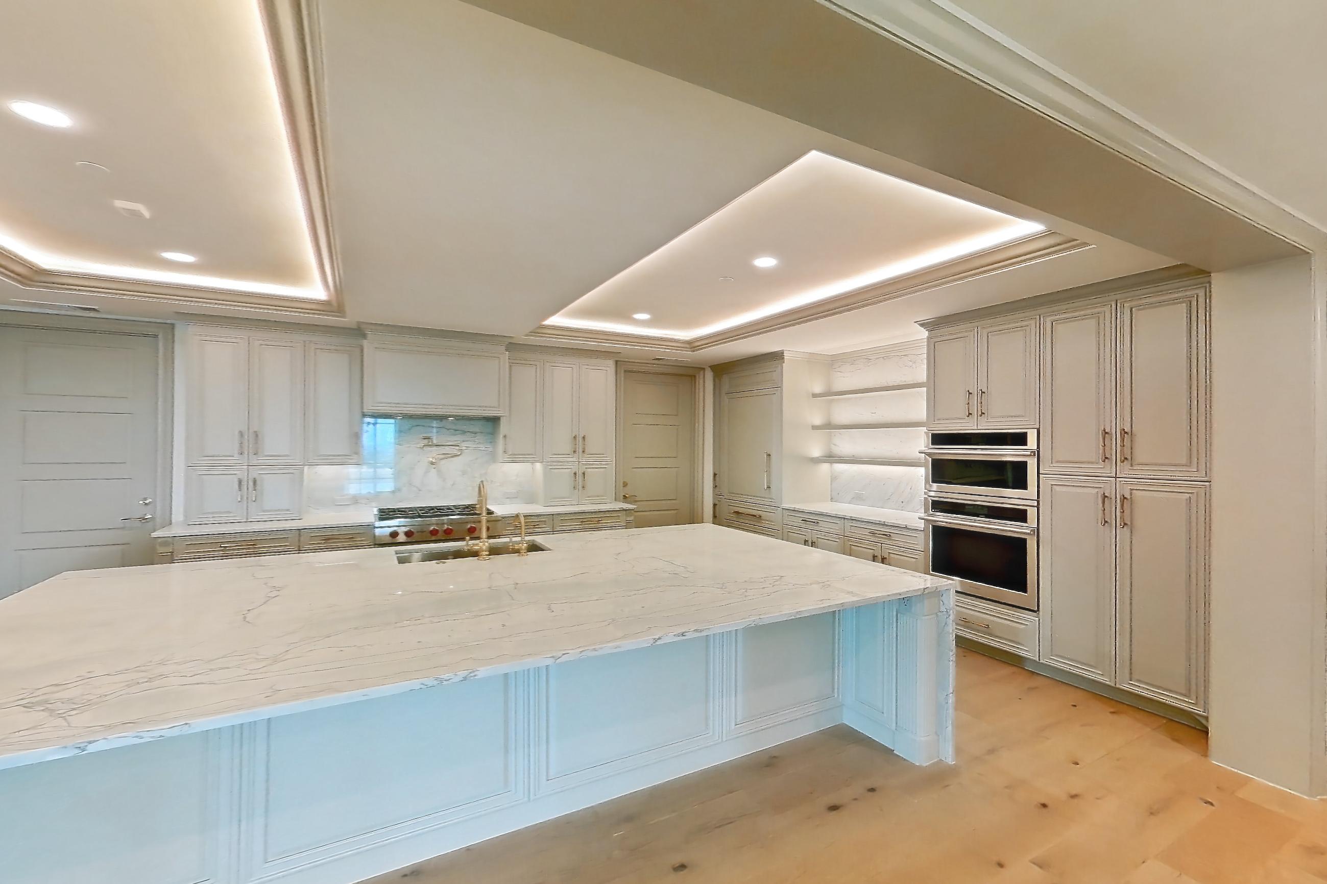 Living space with gas range, kitchen island, light stone countertops, light wood-finish flooring, oven/range, stainless steel appliances, and wood-finish flooring, Apartment 1902 at The Langley