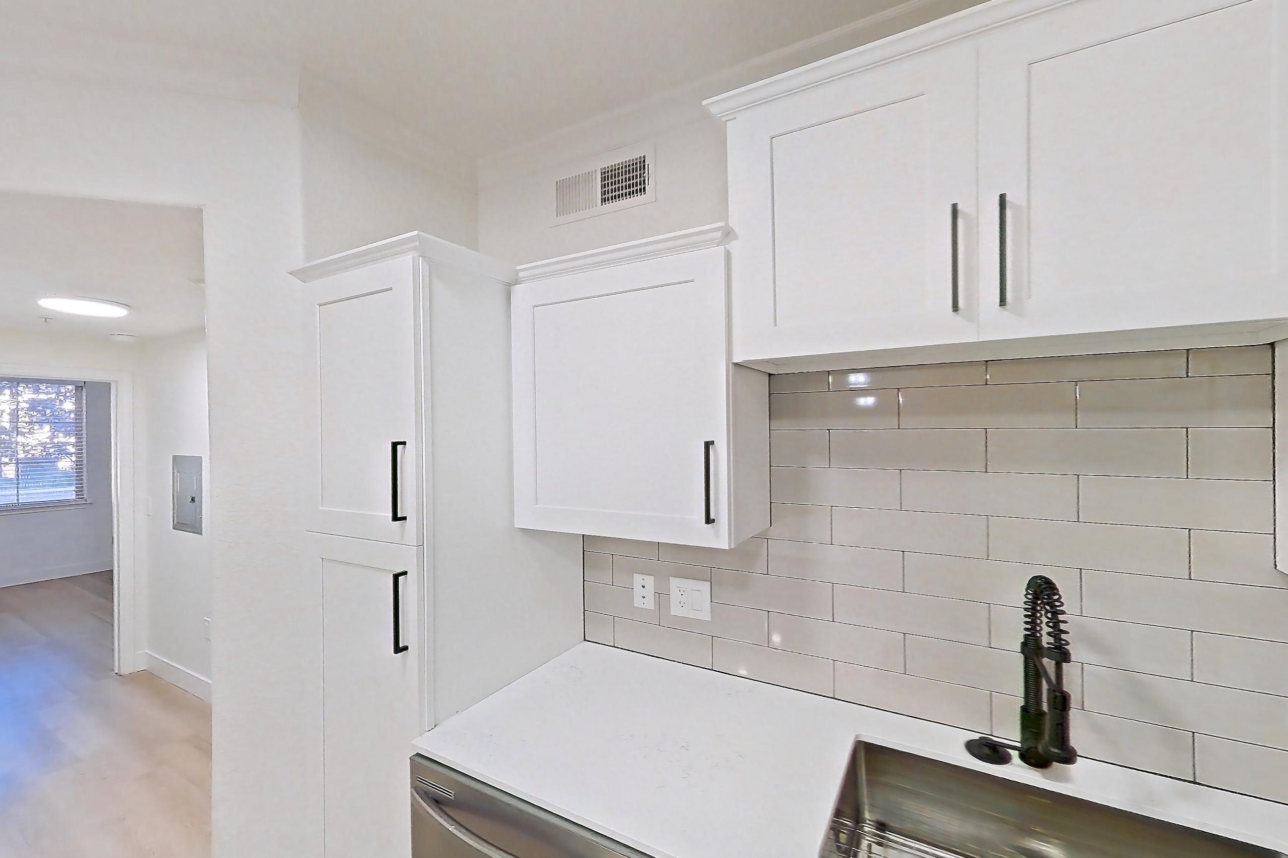 Kitchen with dishwasher, electric range, light countertops, light stone countertops, light wood-finish flooring, microwave, oven/range, refrigerator, and stainless steel appliances, Apartment 30-110 at Terracina