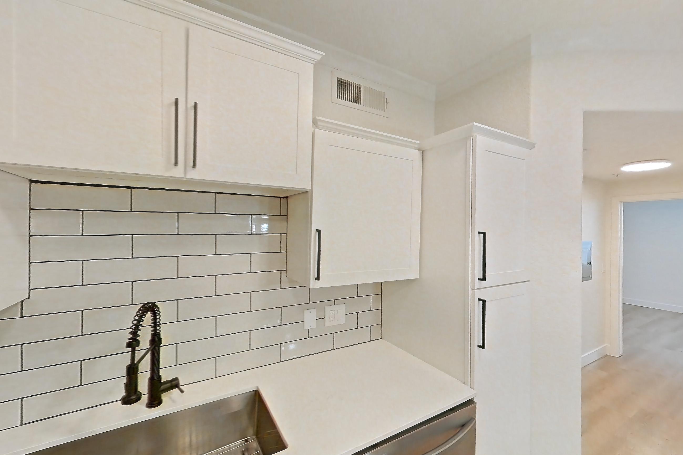Kitchen with dishwasher, electric range, light countertops, light stone countertops, light wood-finish flooring, microwave, oven/range, refrigerator, and stainless steel appliances, Apartment 30-119 at Terracina