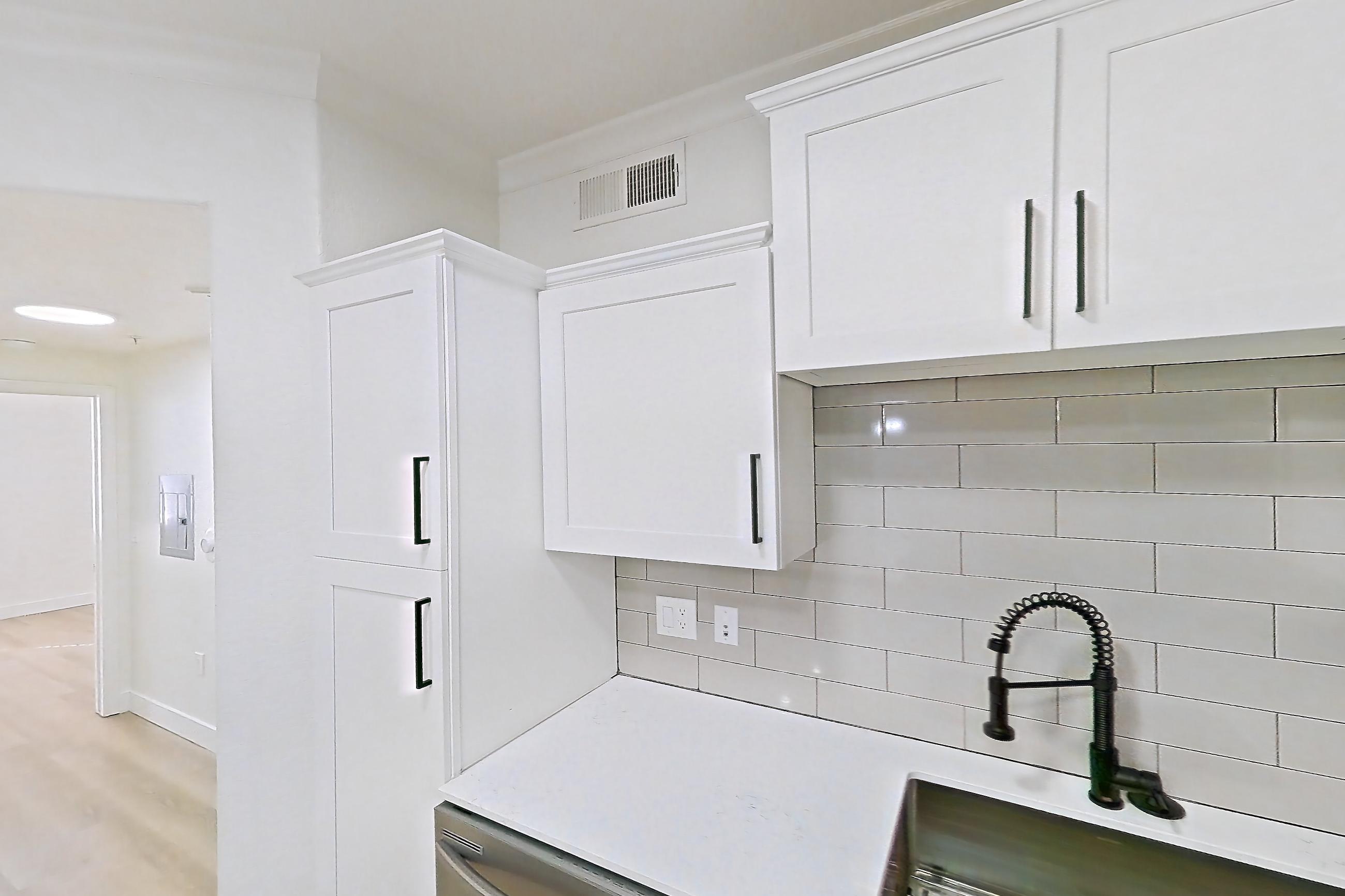 Kitchen with dishwasher, electric range, light countertops, light stone countertops, light wood-finish flooring, microwave, oven/range, refrigerator, and stainless steel appliances, Apartment 30-121 at Terracina