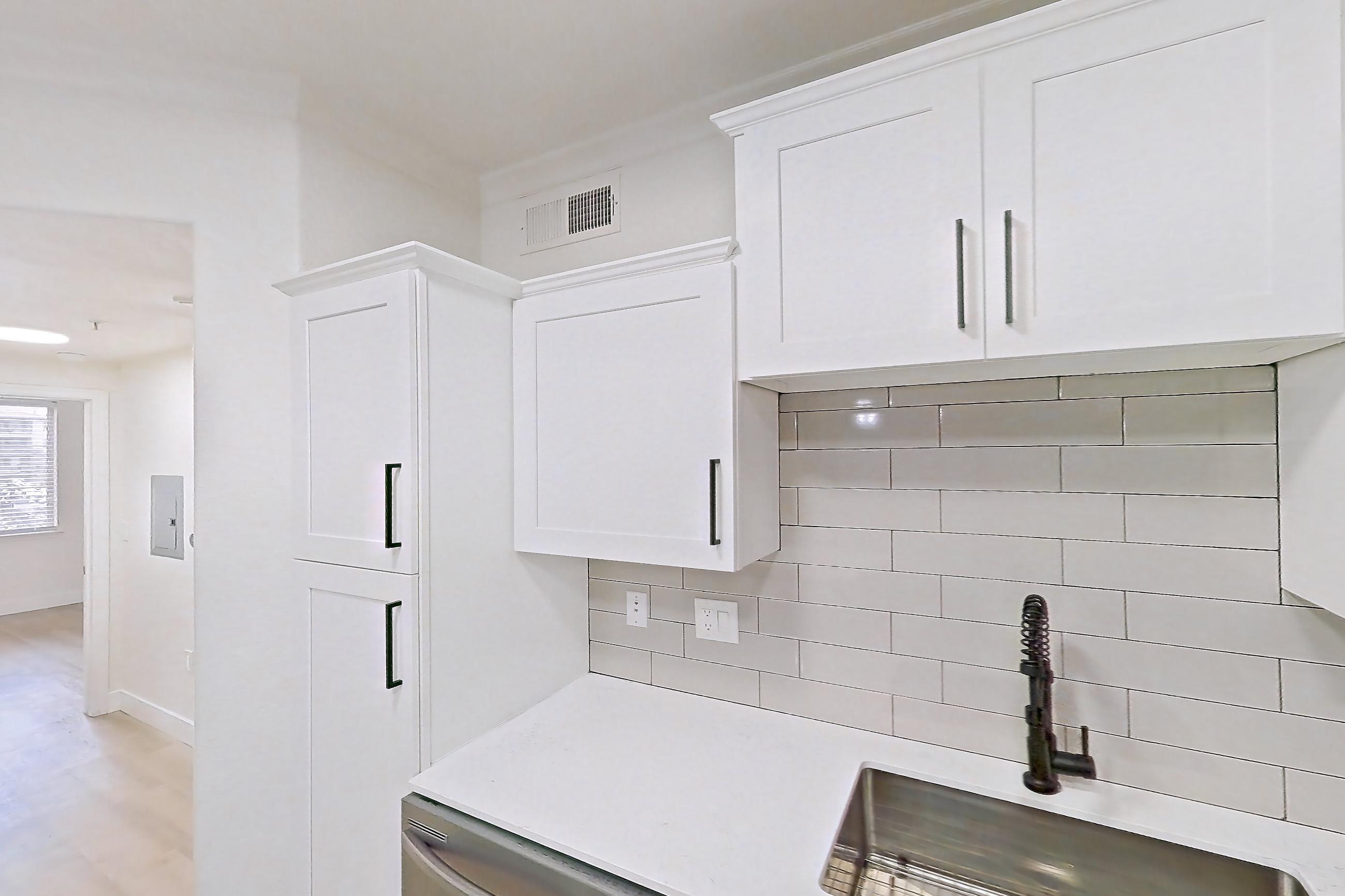 Kitchen with dishwasher, electric range, light countertops, light stone countertops, light wood-finish flooring, microwave, oven/range, refrigerator, and stainless steel appliances, Apartment 30-210 at Terracina