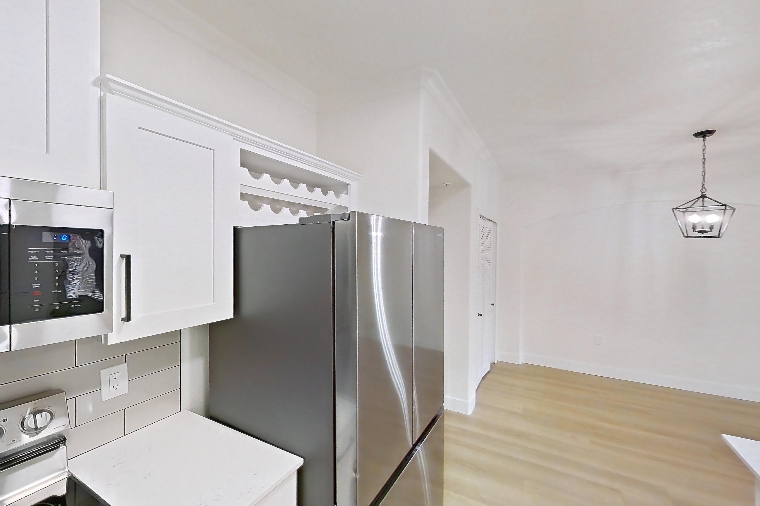 Kitchen with dishwasher, electric range, light countertops, light stone countertops, light wood-finish flooring, microwave, oven/range, refrigerator, and stainless steel appliances, Apartment 30-210 at Terracina