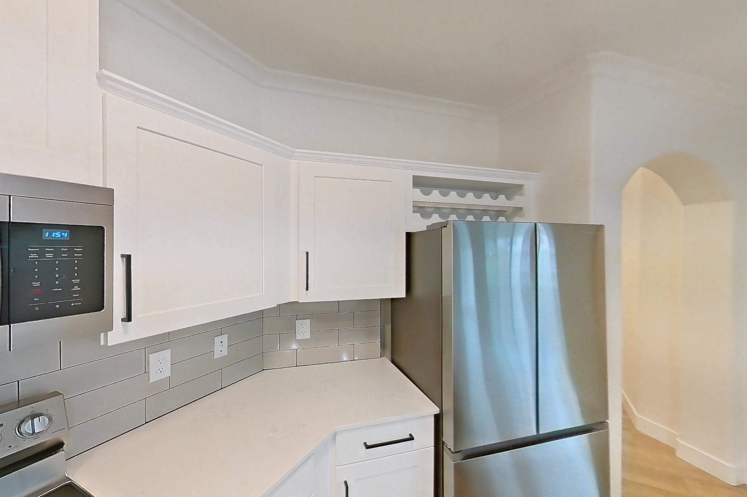 Kitchen with dishwasher, electric range, light countertops, light stone countertops, light wood-finish flooring, microwave, oven/range, refrigerator, and stainless steel appliances, Apartment 50-206 at Terracina