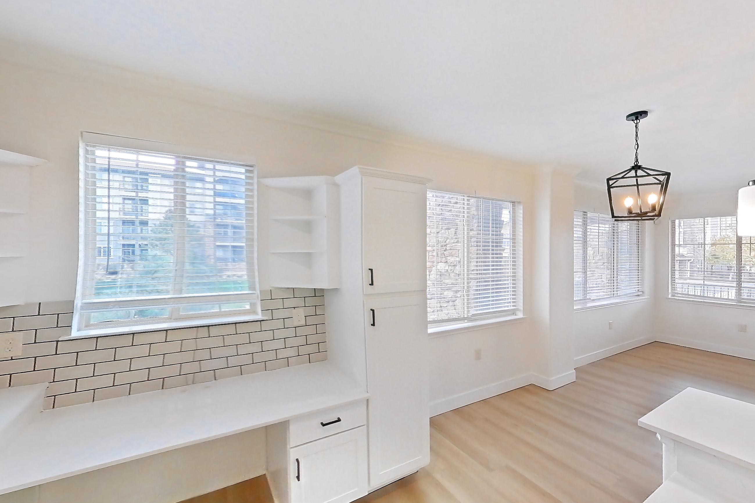 Kitchen with dishwasher, electric range, light countertops, light stone countertops, light wood-finish flooring, microwave, oven/range, refrigerator, and stainless steel appliances, Apartment 60-207 at Terracina