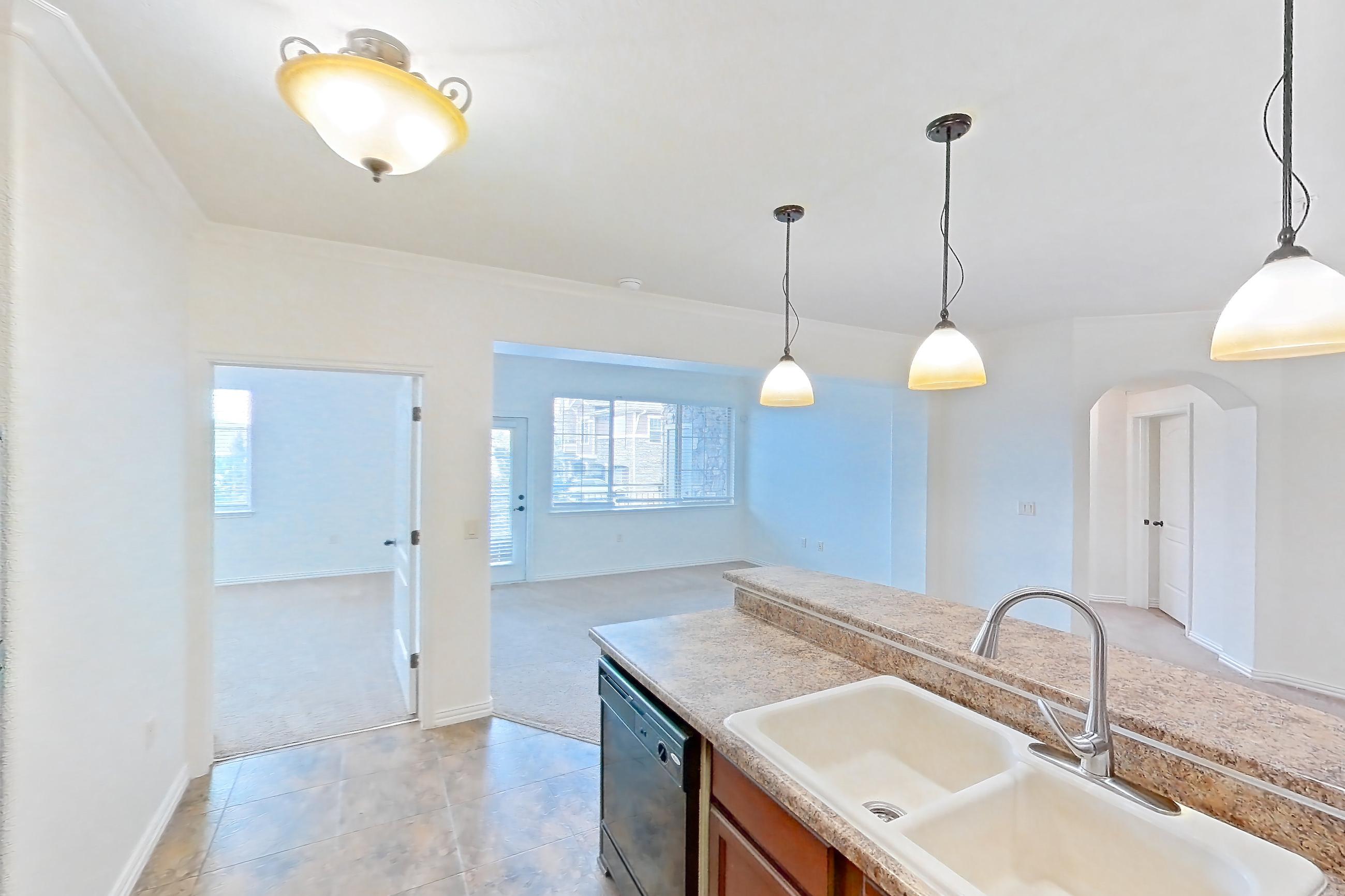 Kitchen with black appliances, dishwasher, electric range, light countertops, light stone countertops, light tile flooring, microwave, oven/range, and refrigerator, Apartment 60-209 at Terracina