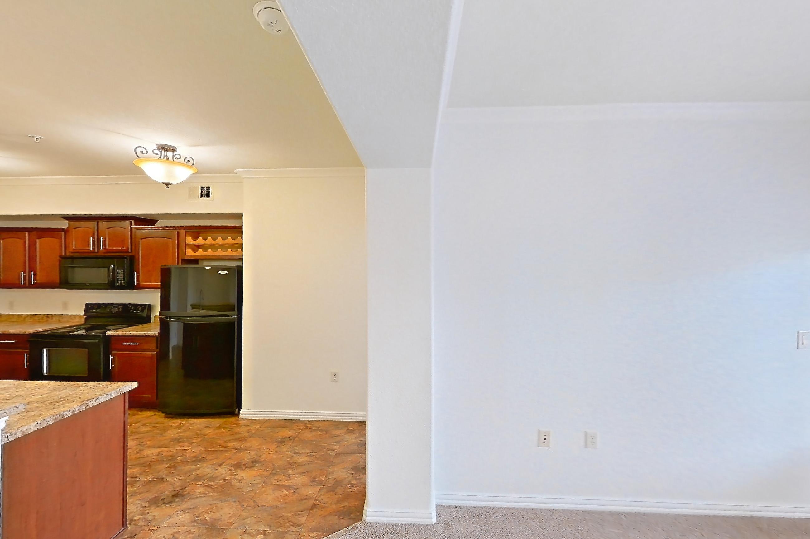 Living space with black appliances, dark carpet, electric range, kitchen island, light countertops, oven/range, and refrigerator, Apartment 60-209 at Terracina