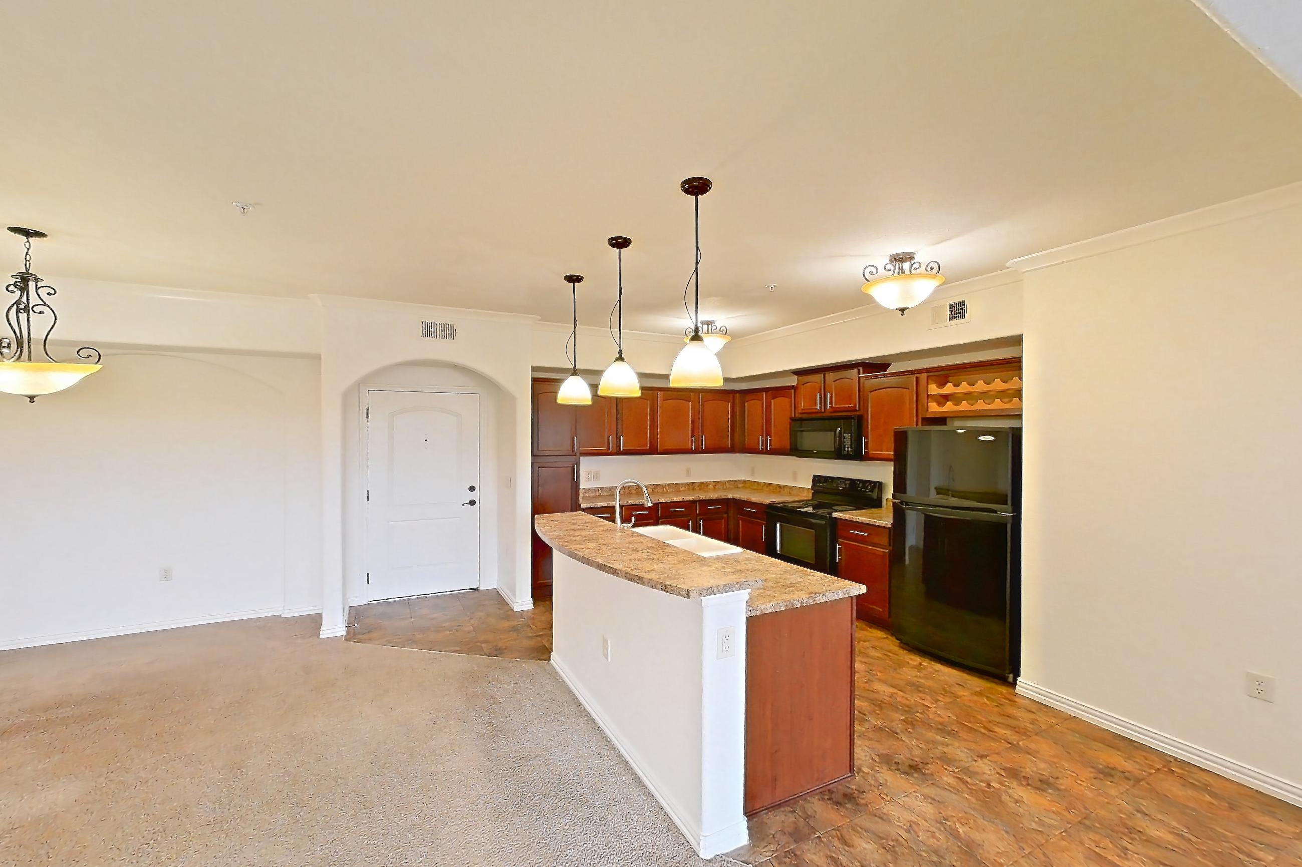 Living space with black appliances, dark carpet, electric range, kitchen island, light countertops, oven/range, and refrigerator, Apartment 60-209 at Terracina