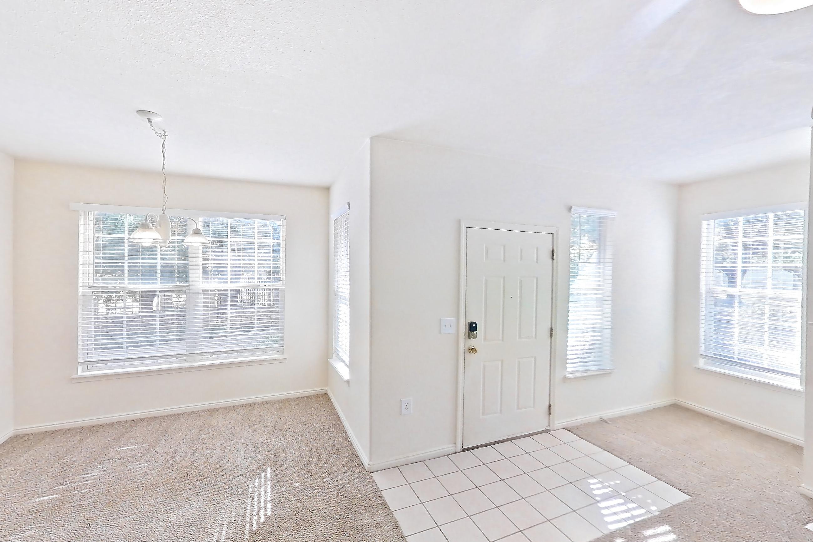 Living space with fireplace, light carpet, light tile flooring, oven/range, tile fireplace, and white appliances, Apartment 01-105 at Eagle Ridge