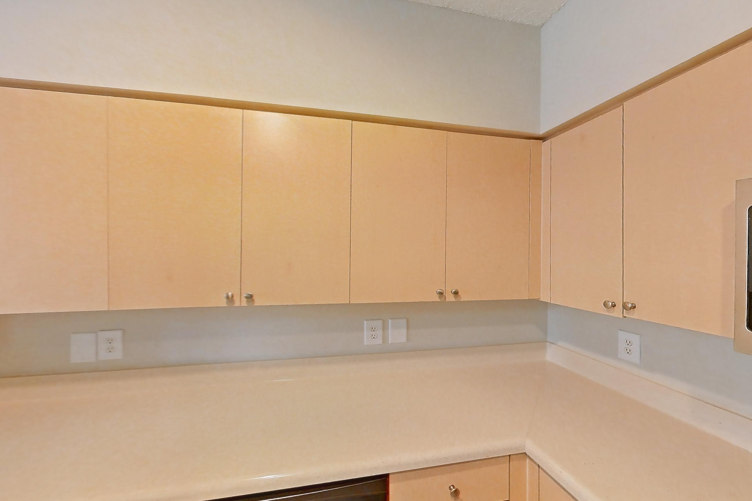 Kitchen with dishwasher, electric range, light countertops, light tile flooring, microwave, refrigerator, and stainless steel appliances, Apartment 06-108 at Miramar Lakes