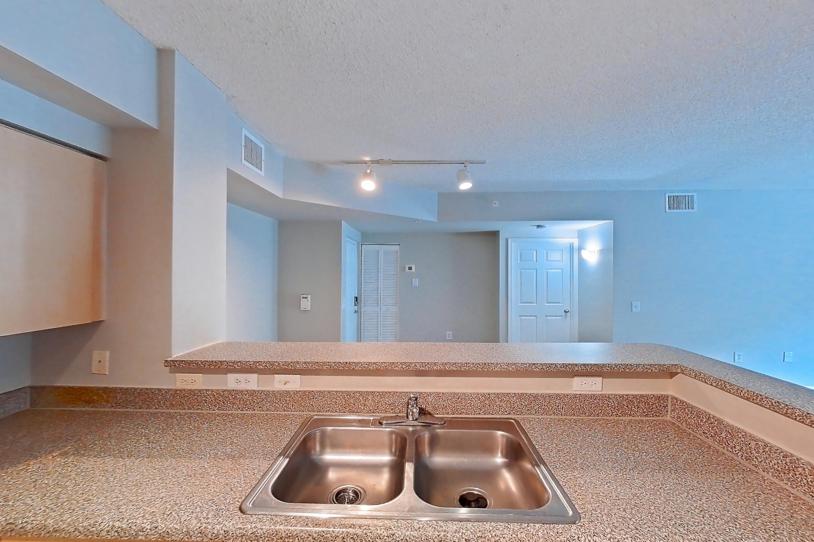 Kitchen with dishwasher, electric range, light countertops, light tile flooring, microwave, oven/range, and stainless steel appliances, Apartment 10-105 at Miramar Lakes