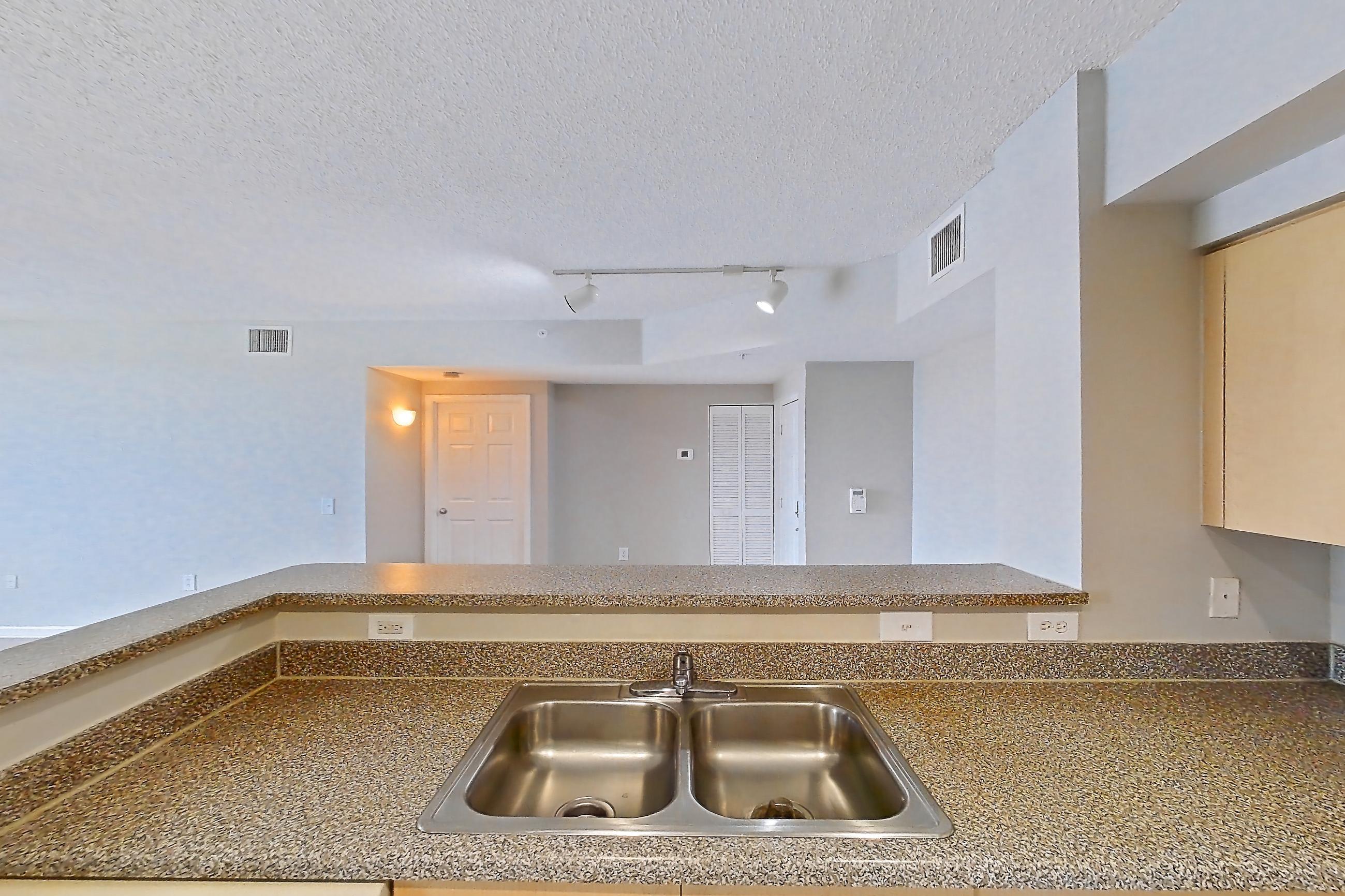 Kitchen with dark countertops, dishwasher, electric range, light tile flooring, microwave, oven/range, and white appliances, Apartment 13-206 at Miramar Lakes