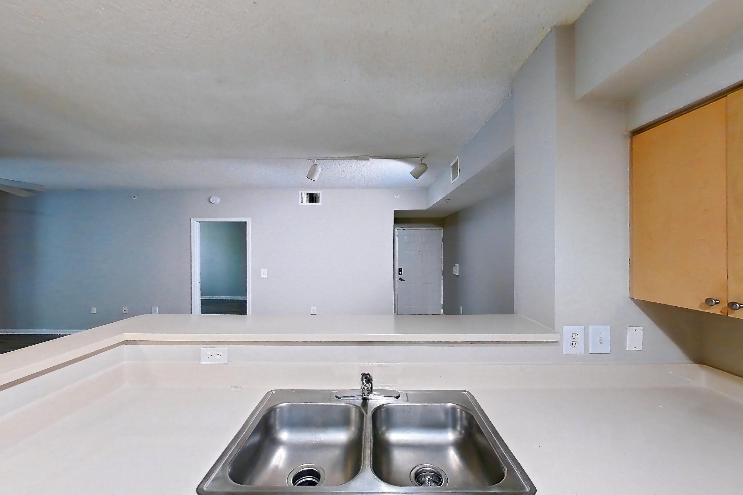 Kitchen with dishwasher, electric range, light countertops, light tile flooring, microwave, oven/range, refrigerator, and white appliances, Apartment 12-207 at Miramar Lakes