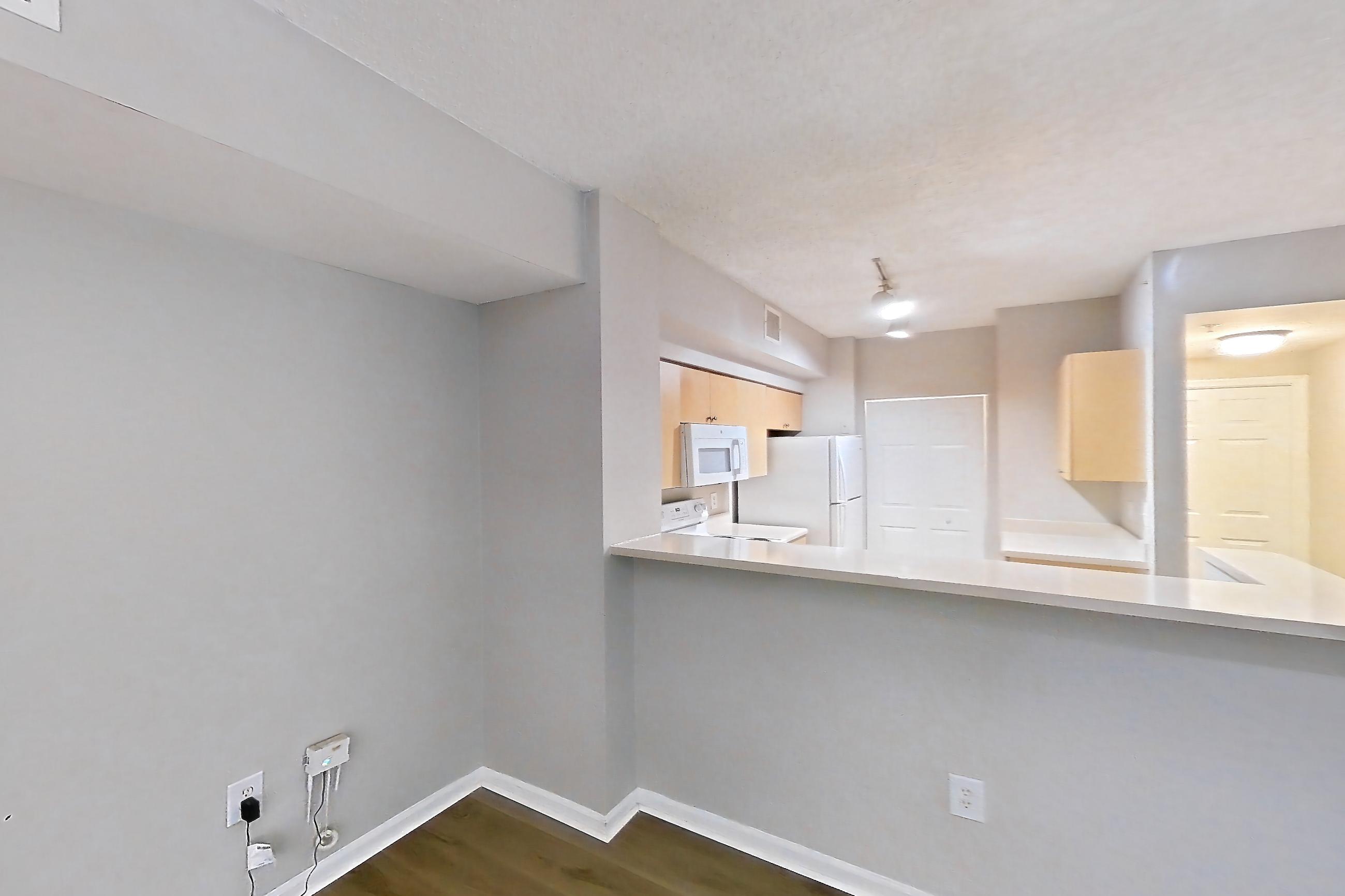 Living space with light wood-finish flooring, oven/range, refrigerator, and white appliances, Apartment 12-207 at Miramar Lakes