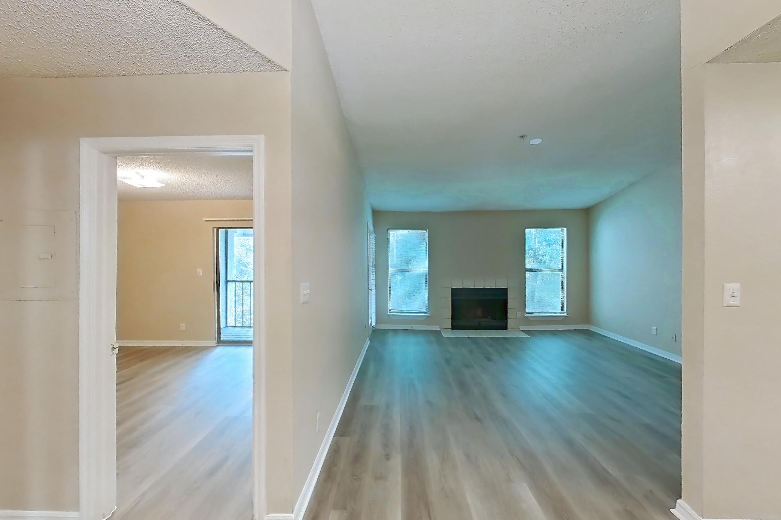 Dining room with black appliances, dark countertops, electric range, fireplace, light countertops, light wood-finish flooring, oven/range, range hood, and tile fireplace, Apartment 0222 at The Dawson